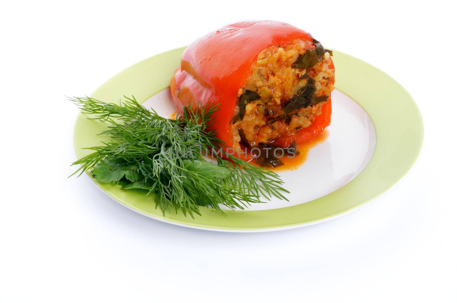 Homemade Red Bell Pepper Filled with Rice, Meat, Onion and Parsley on green plate isolated on white background