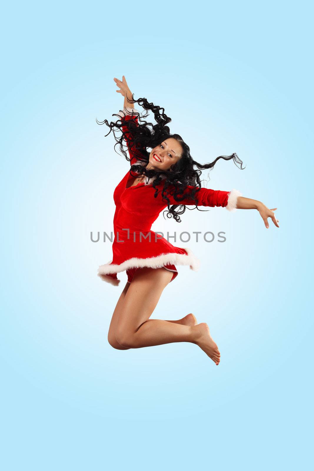 Happy smiling woman in red xmas costume jumping high