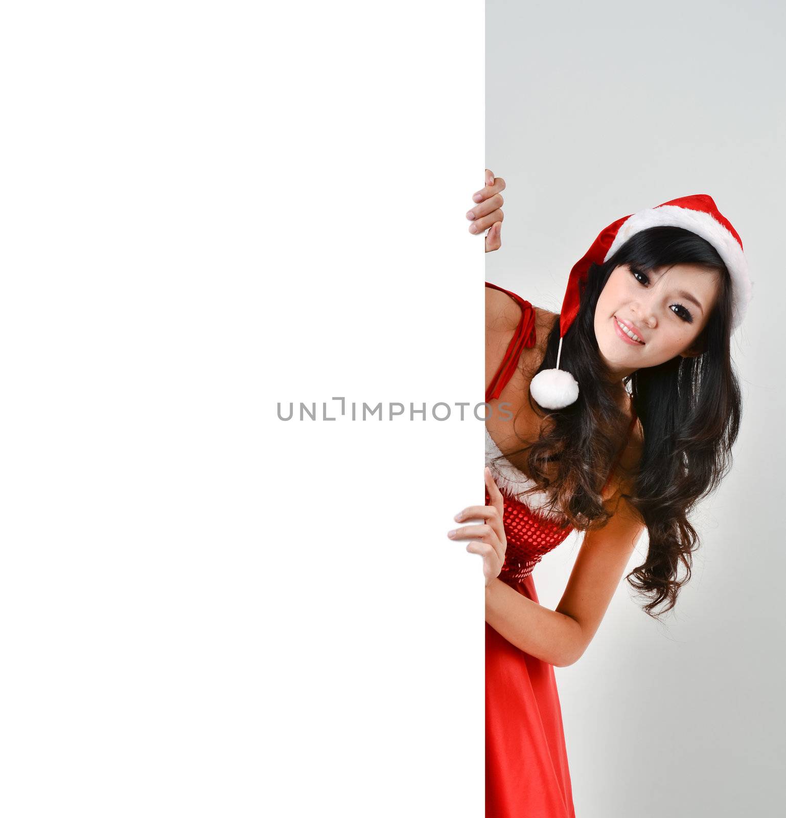 Santa woman  holding a white poster isolated a on gray background