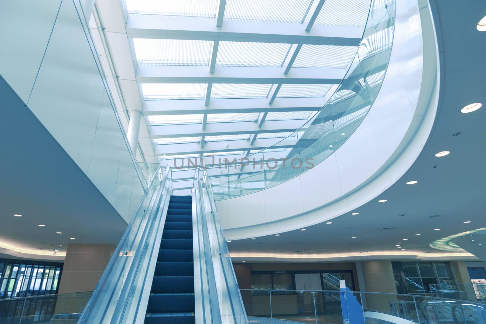 modern interior with escalator moving up to the glass roof