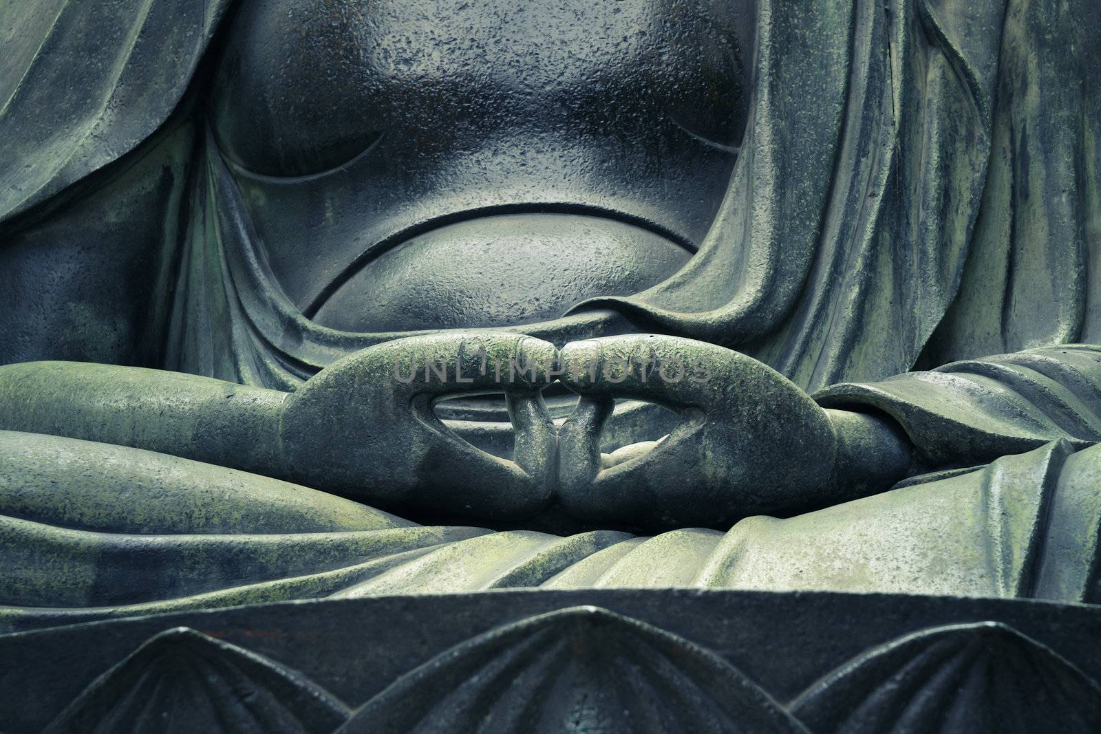 detailed image of Buddha's sculpture hands in peaceful pose; focus on hands