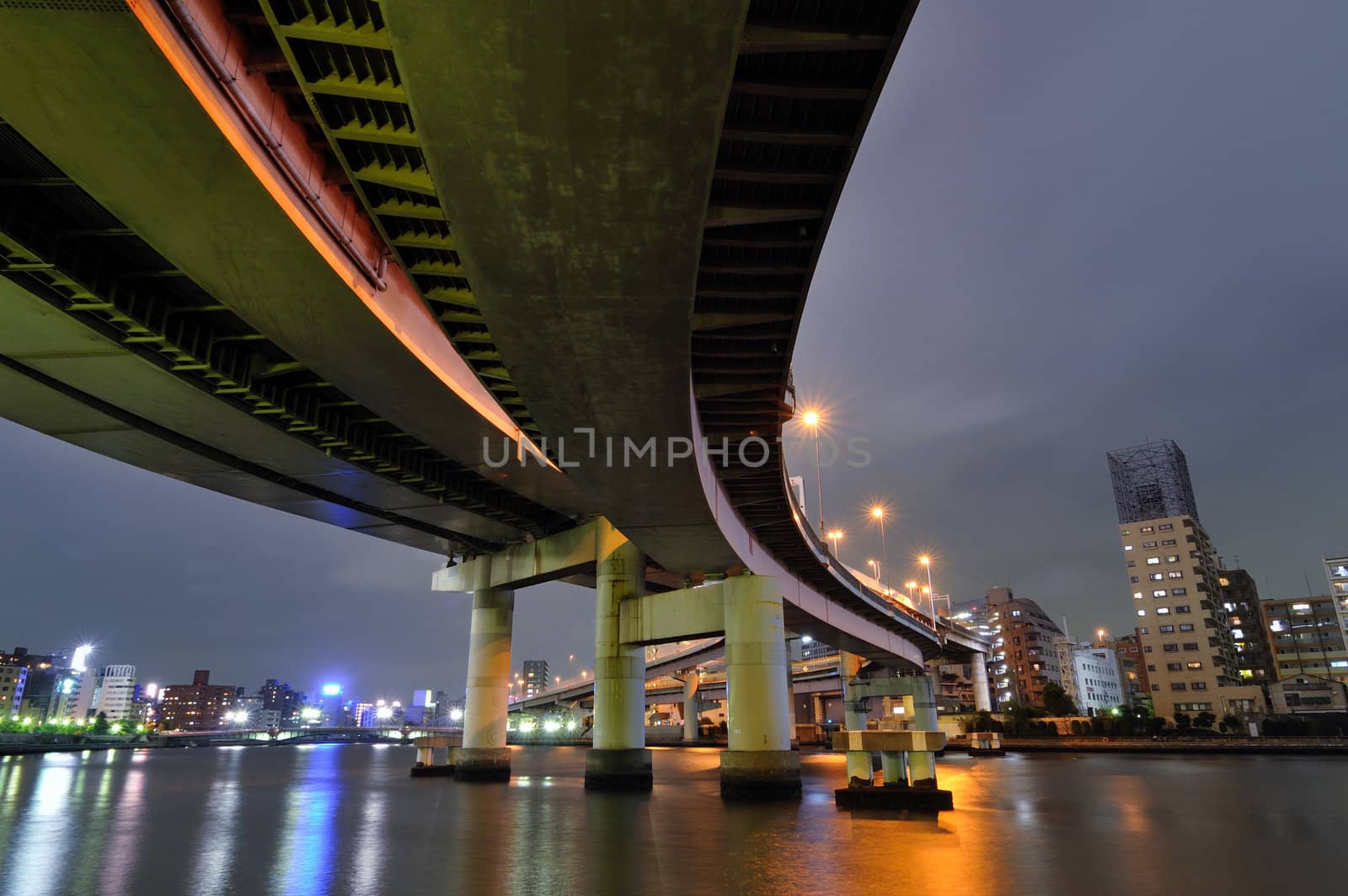 hanged up huge highway structure over river waters by night