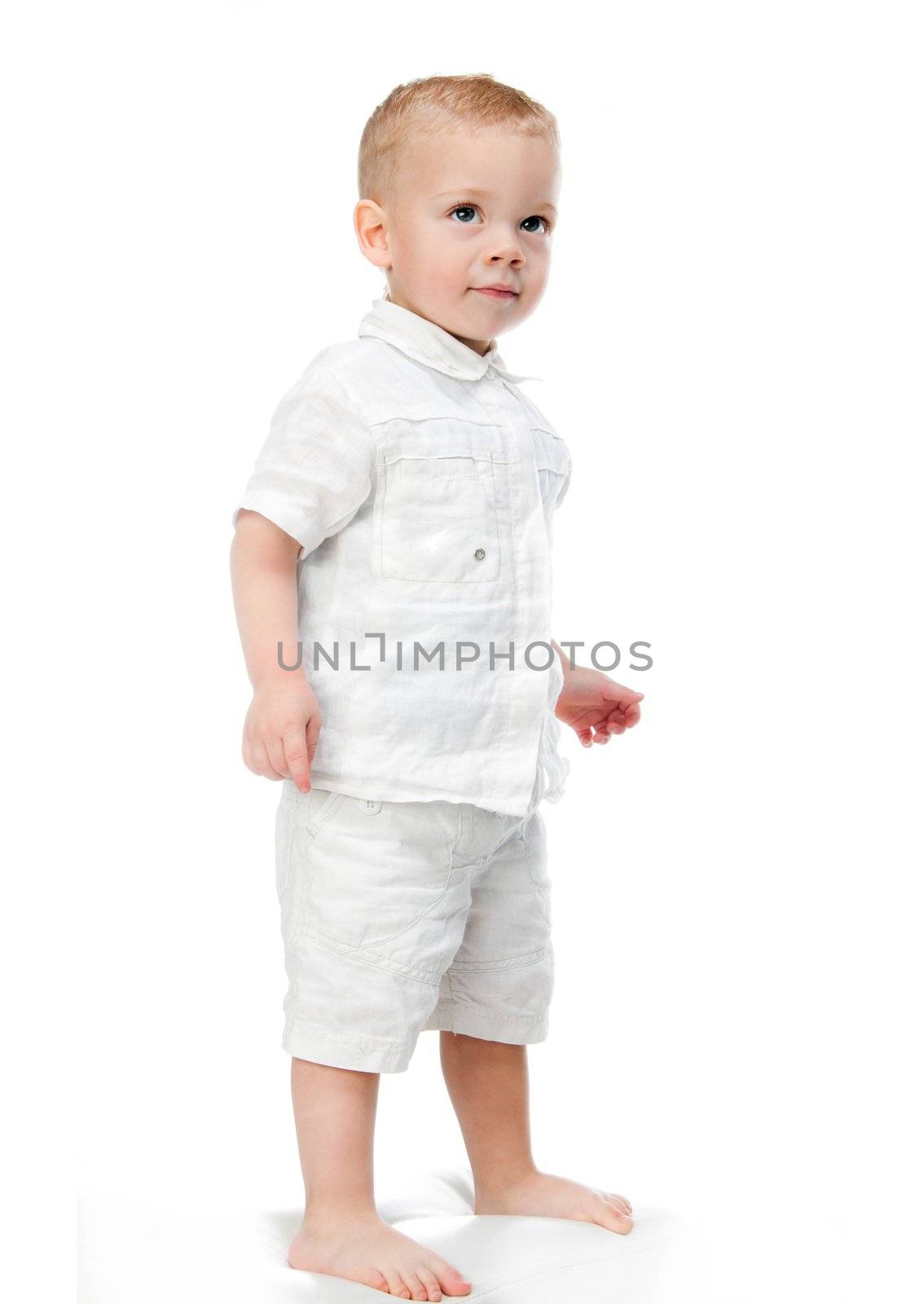 Full length portrait of a happy little boy standing isolated over white background