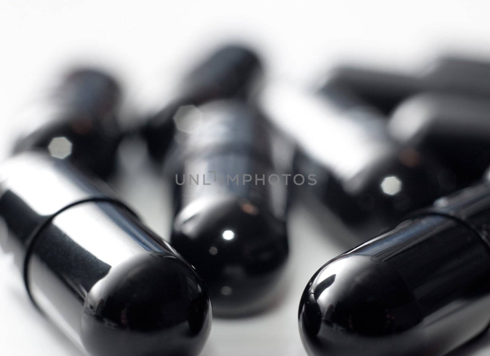 Macro of black capsules on white background