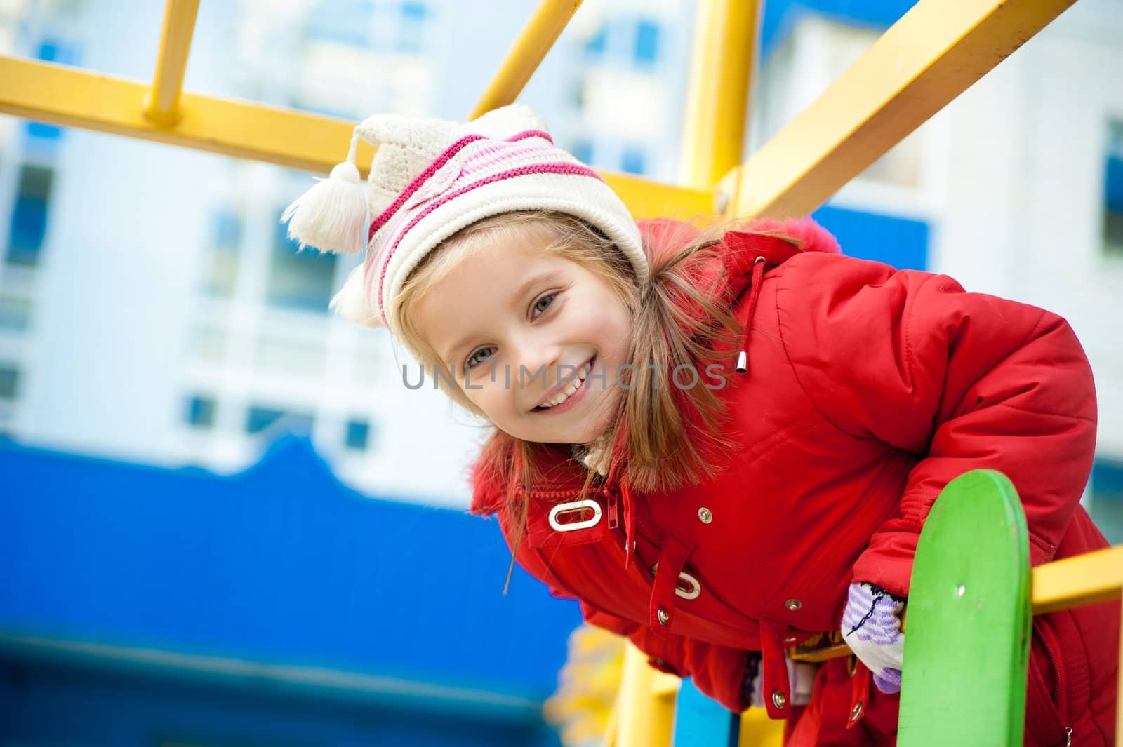 Cute little girl on outdoor playground looking at camera