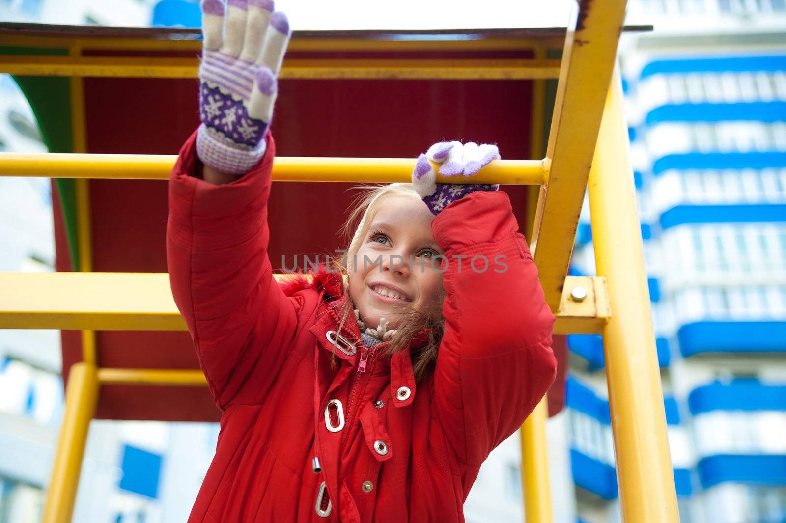 Cute girl on outdoor playground equipment