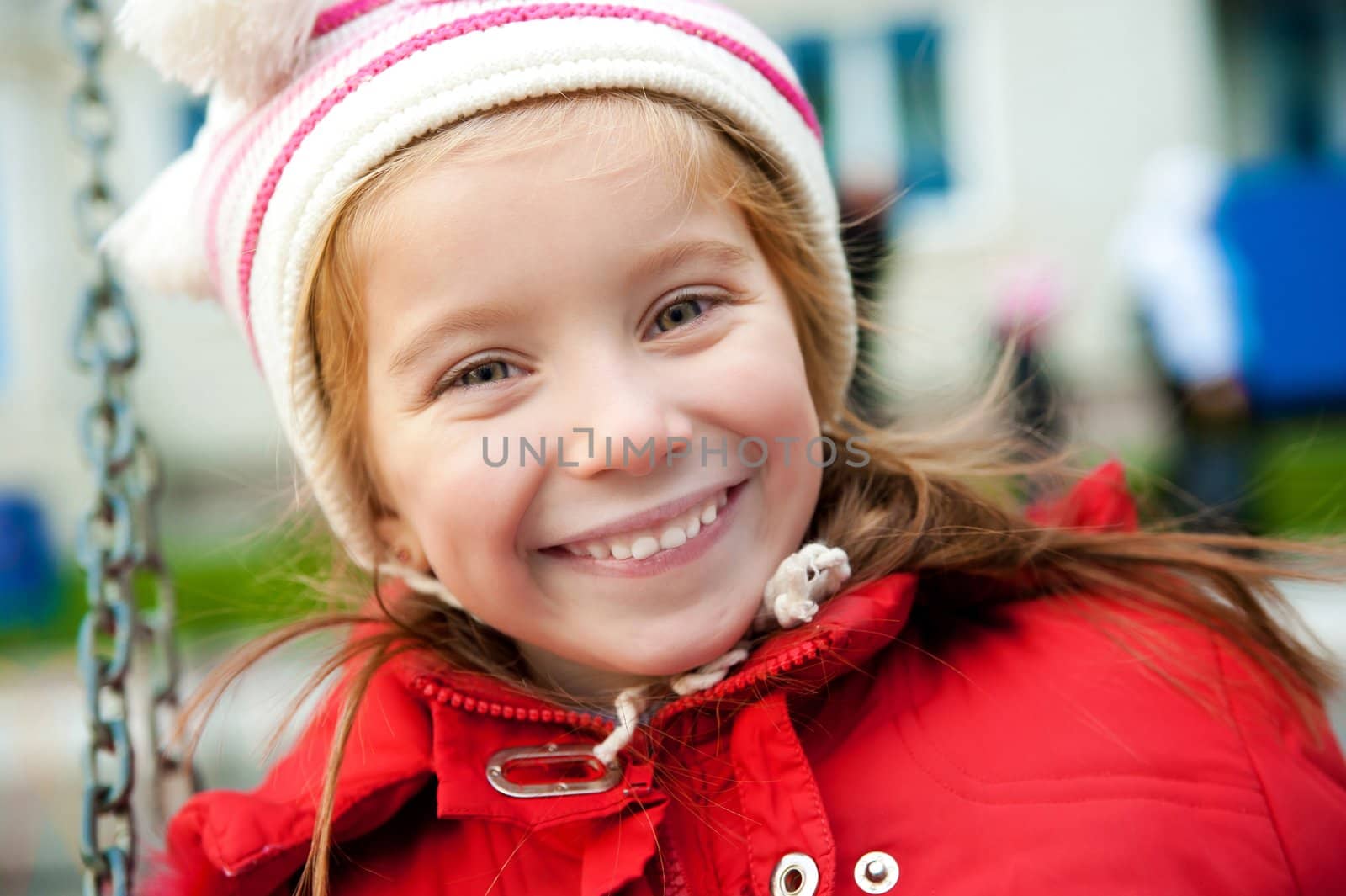 Smiling face of little girl on outdoor playground equipment