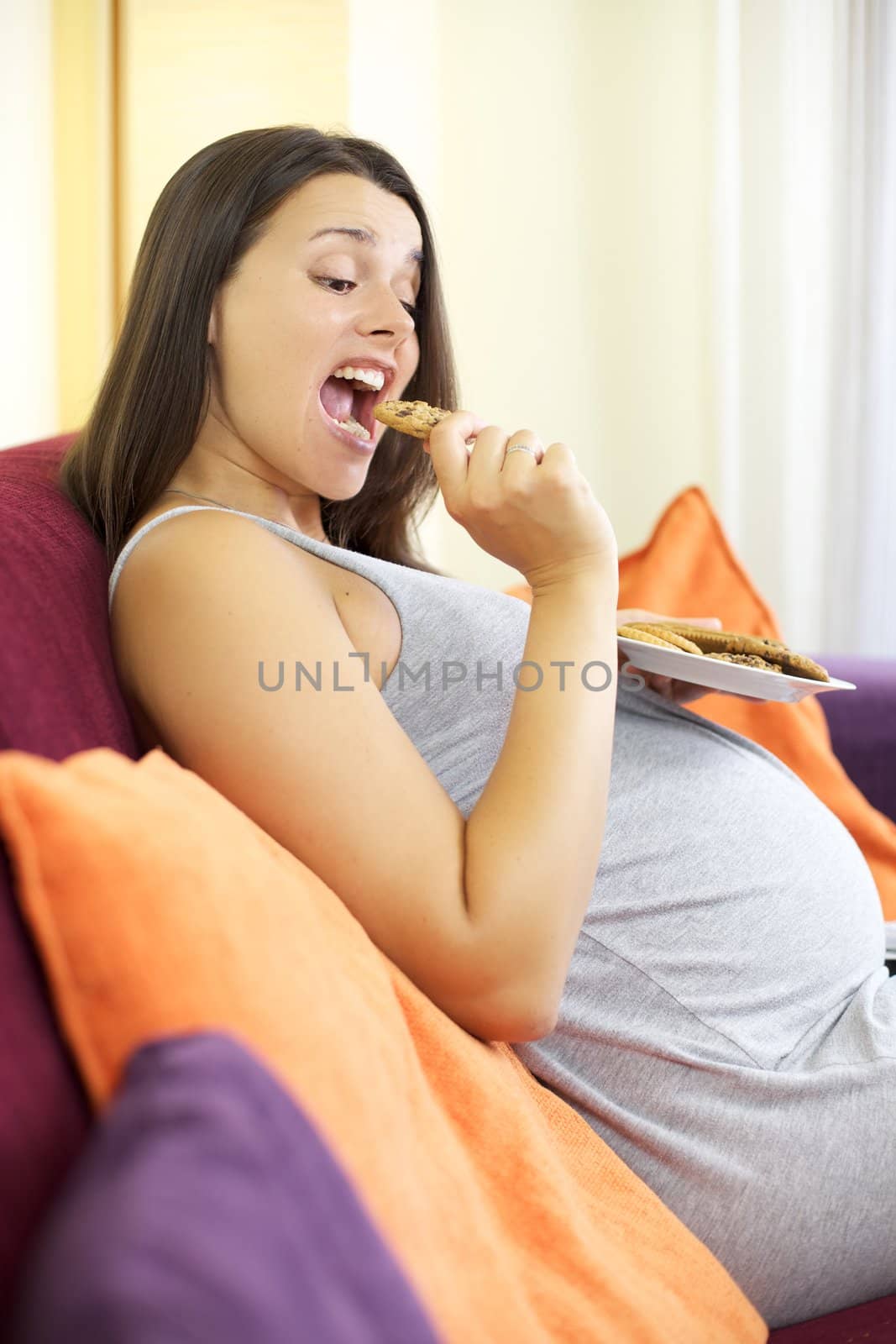 Pregnant woman eating cooky dessert happy by fmarsicano