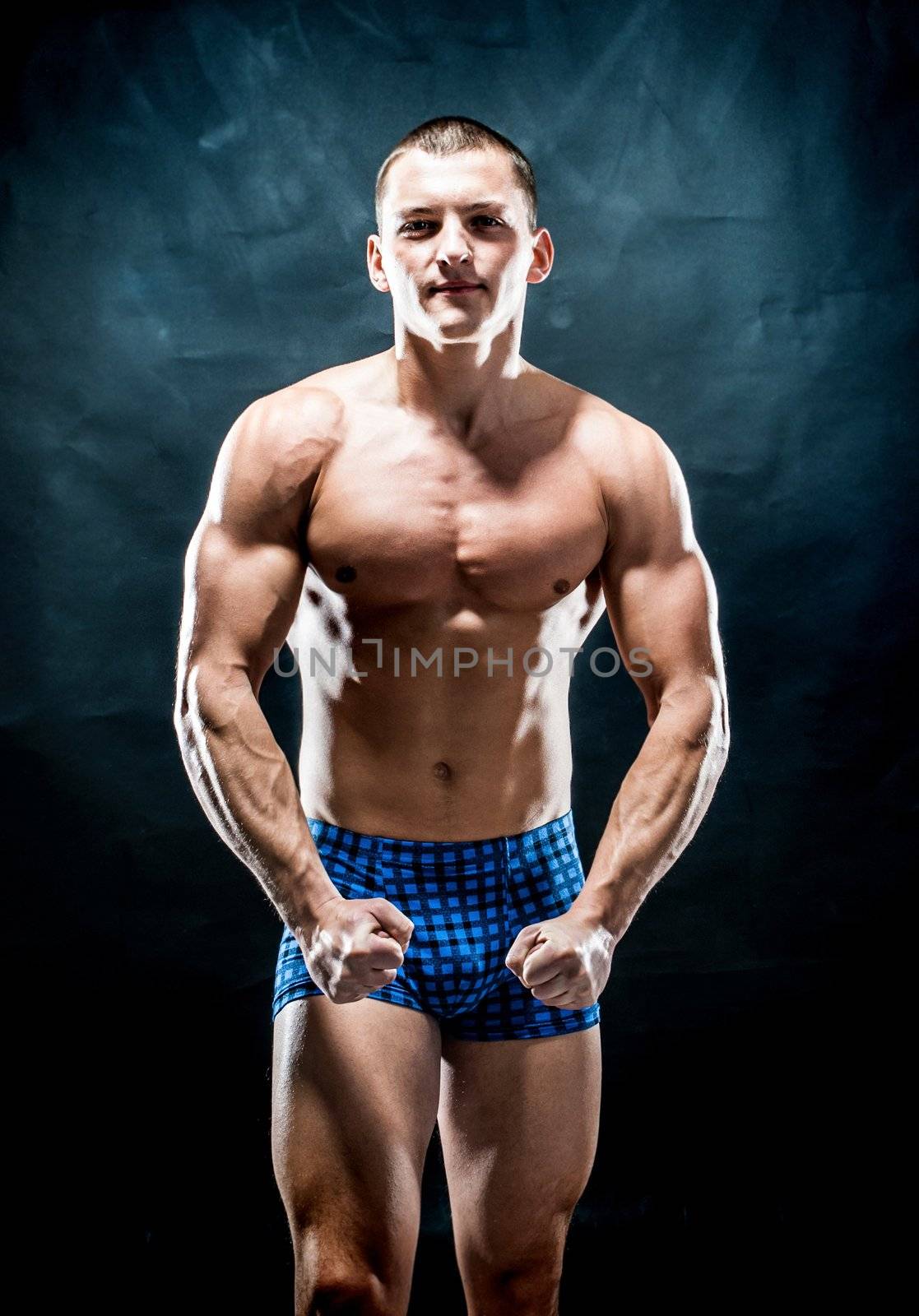 strong athletic man on dark background