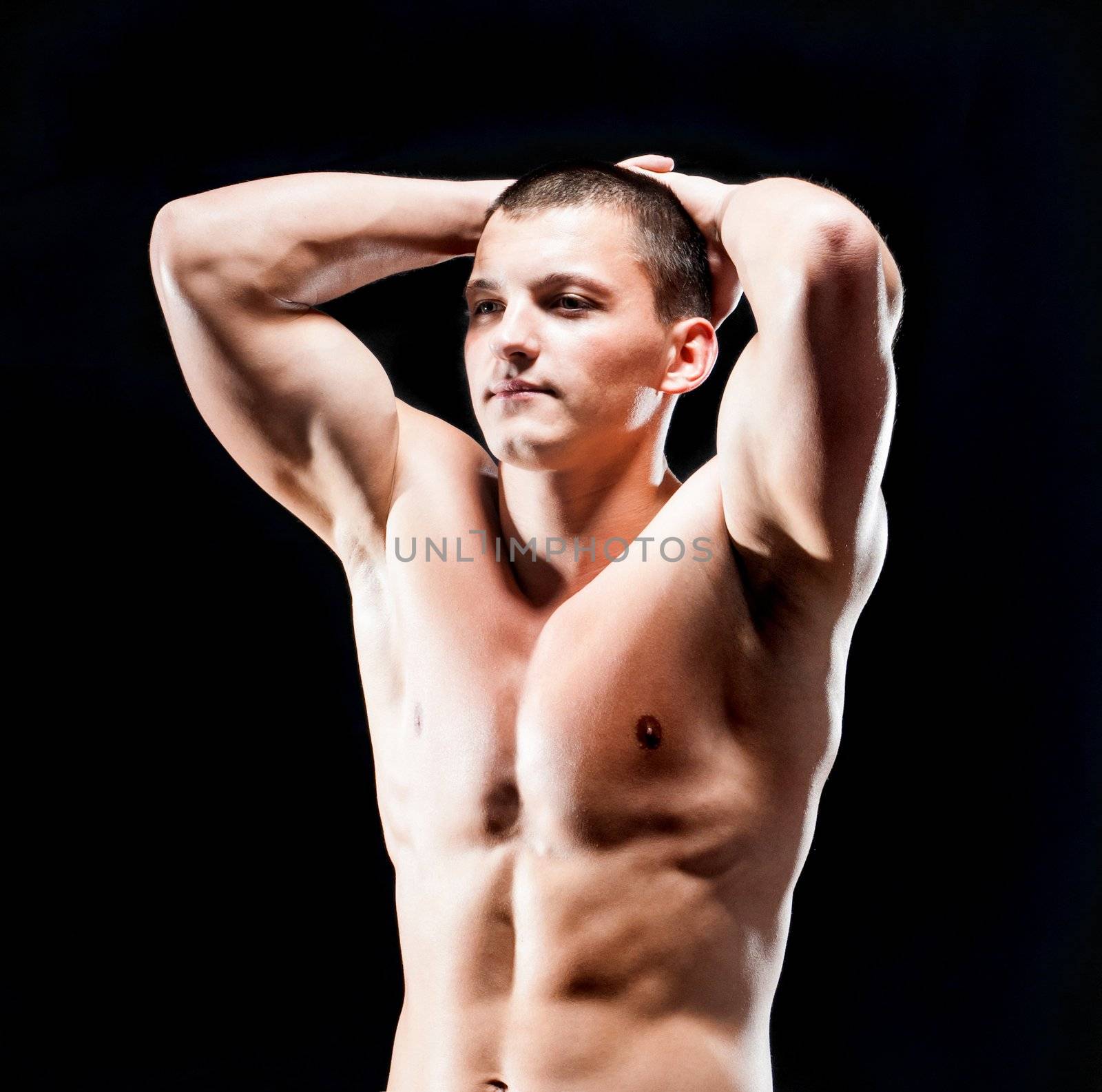 strong athletic man on black background