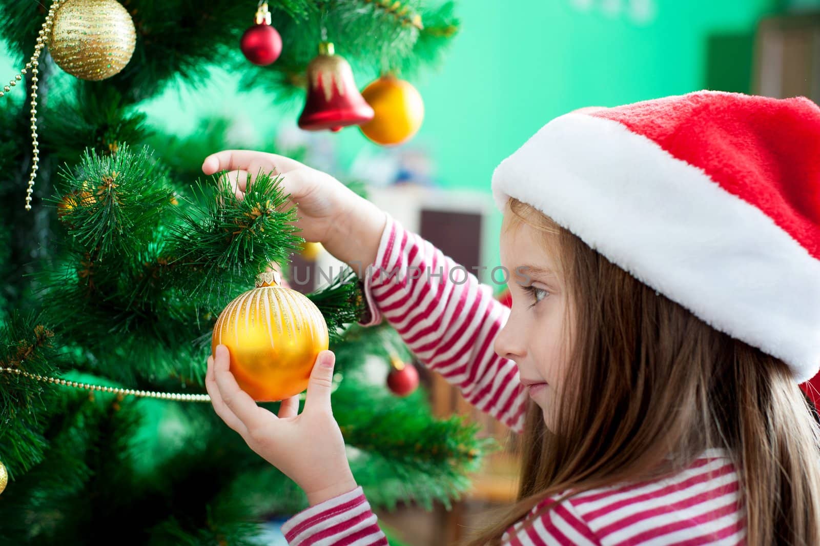 Beautiful little girl in Santa hat with Christmas decoration