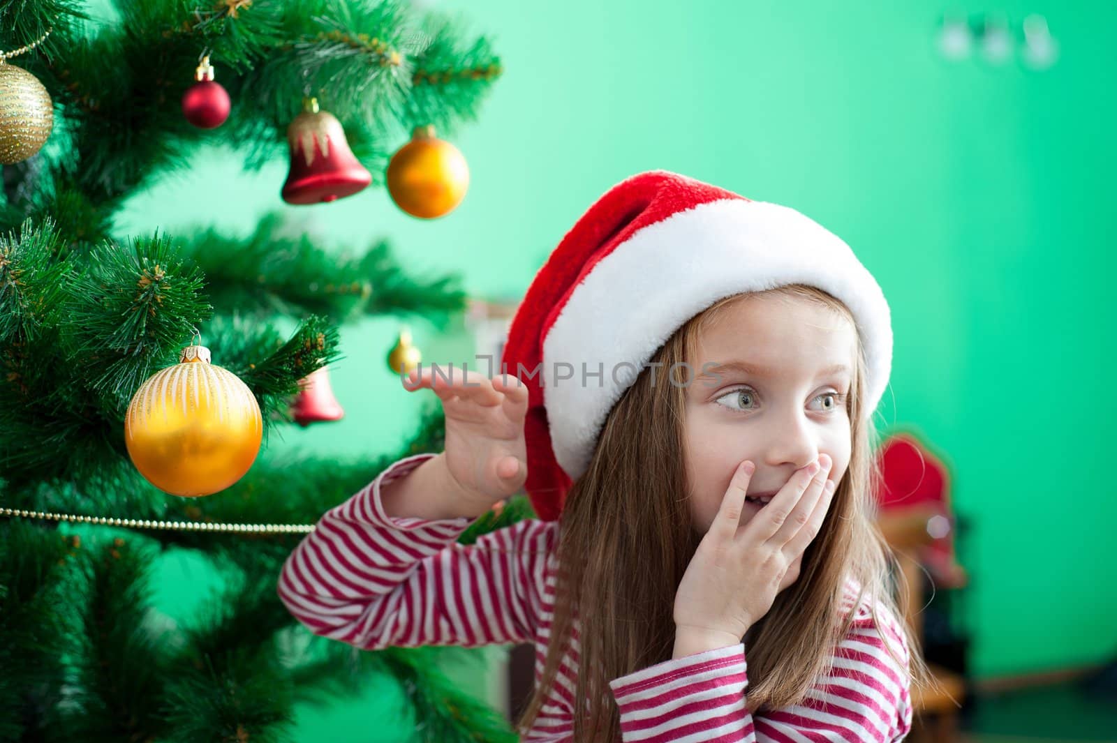 Little girl in Santa hat with Christmas decoration