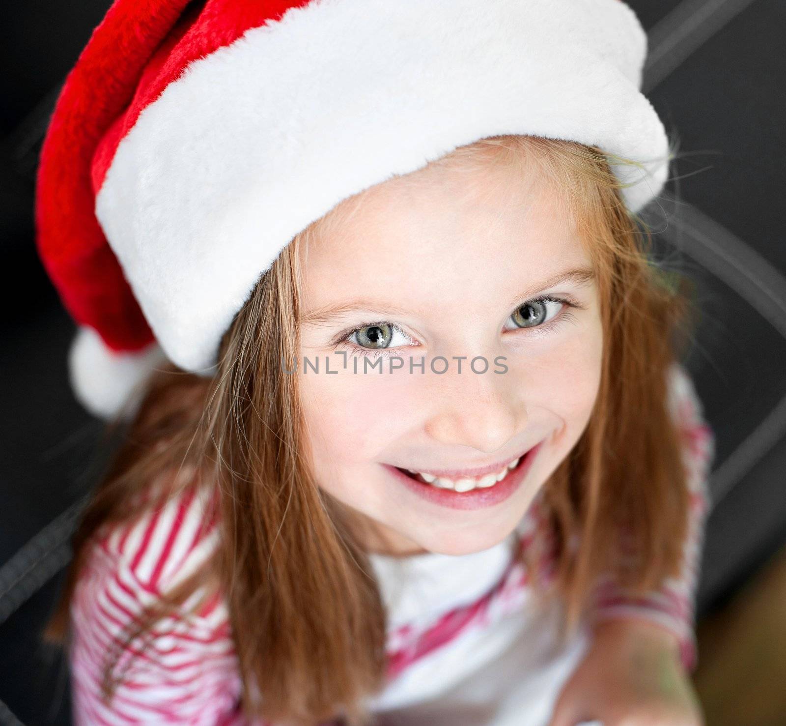 portrait of beautiful happy christmas child in santa hat closeup