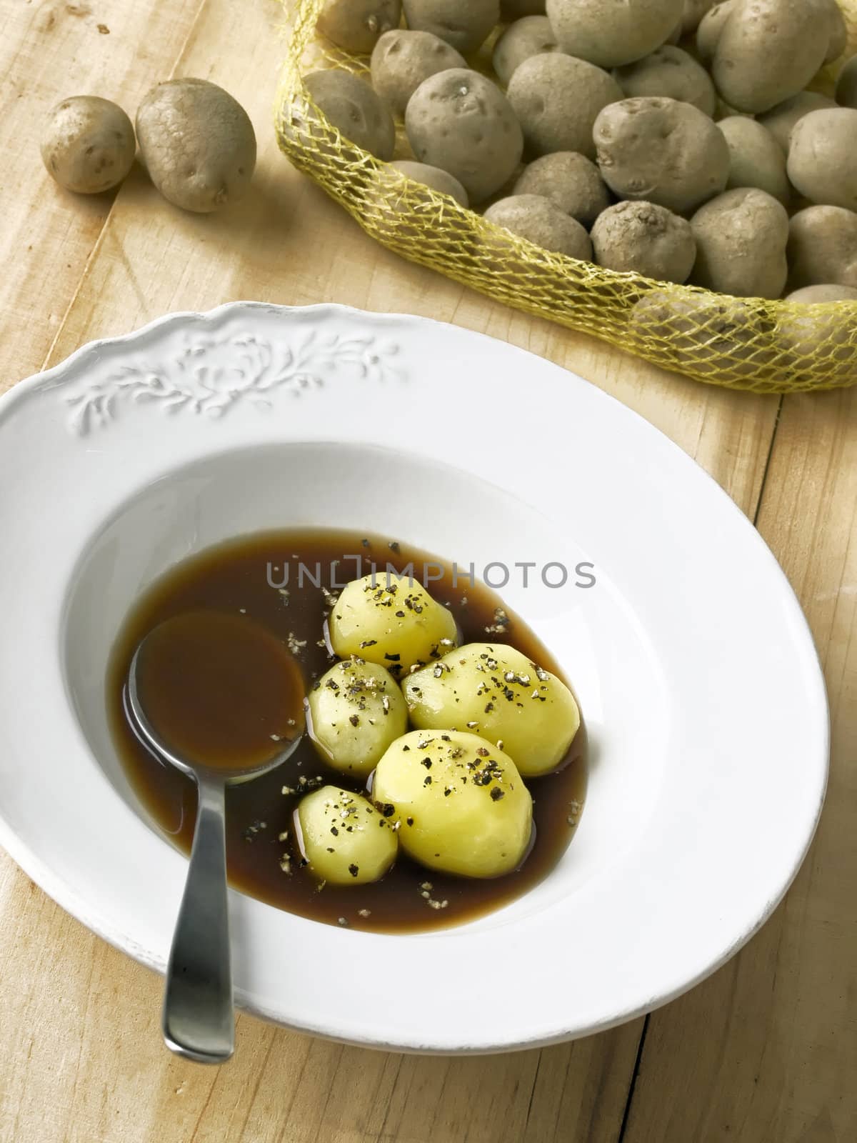 close up of a plate of boiled potatoes in brown sauce