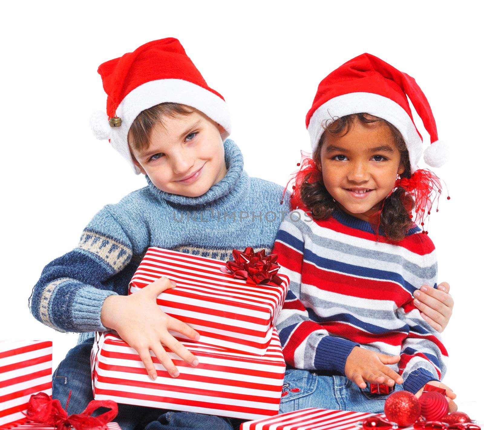 Smiling little mullato girl and her brather in Santa's hat with gift box, isolated on white