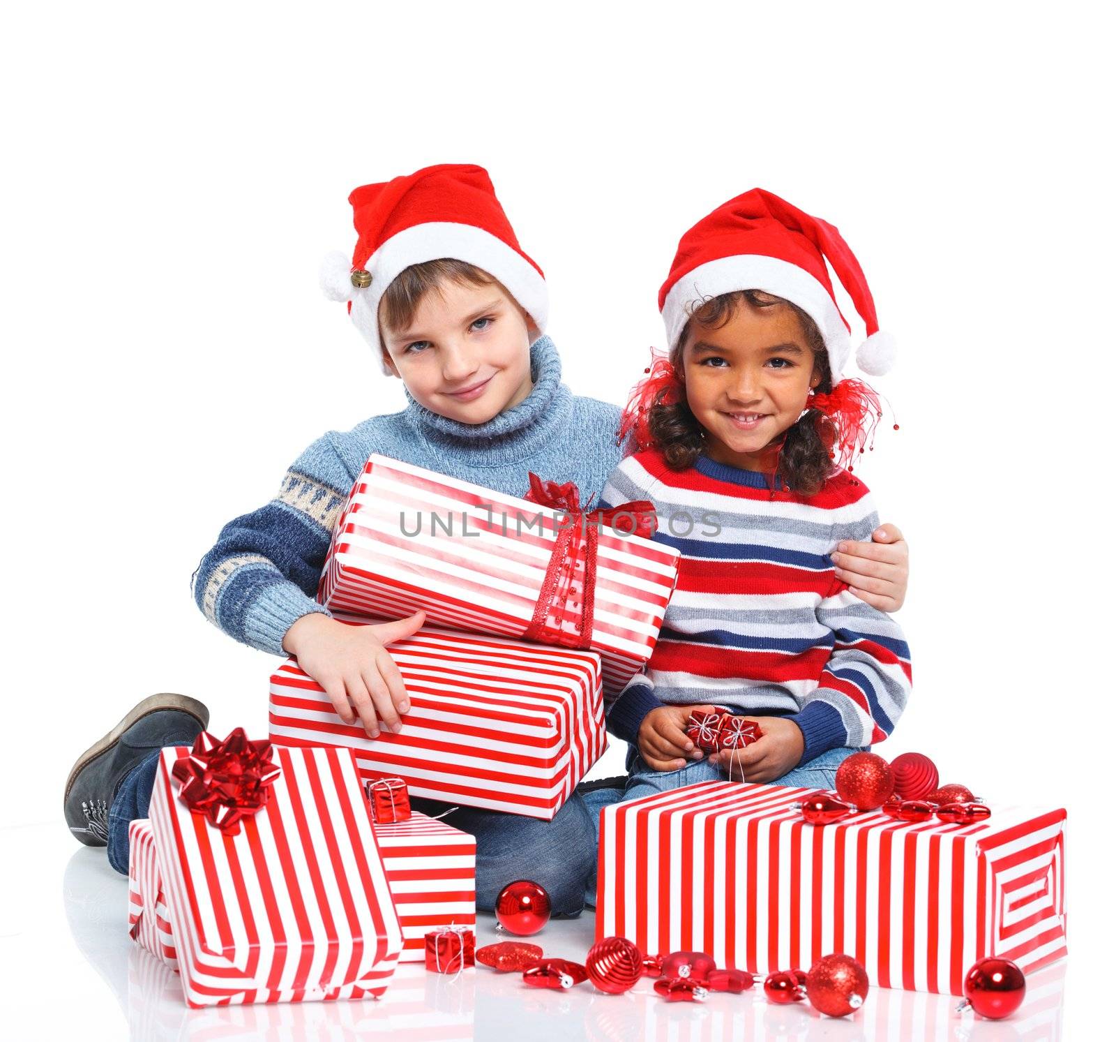 Smiling little mullato girl and her brather in Santa's hat with gift box, isolated on white