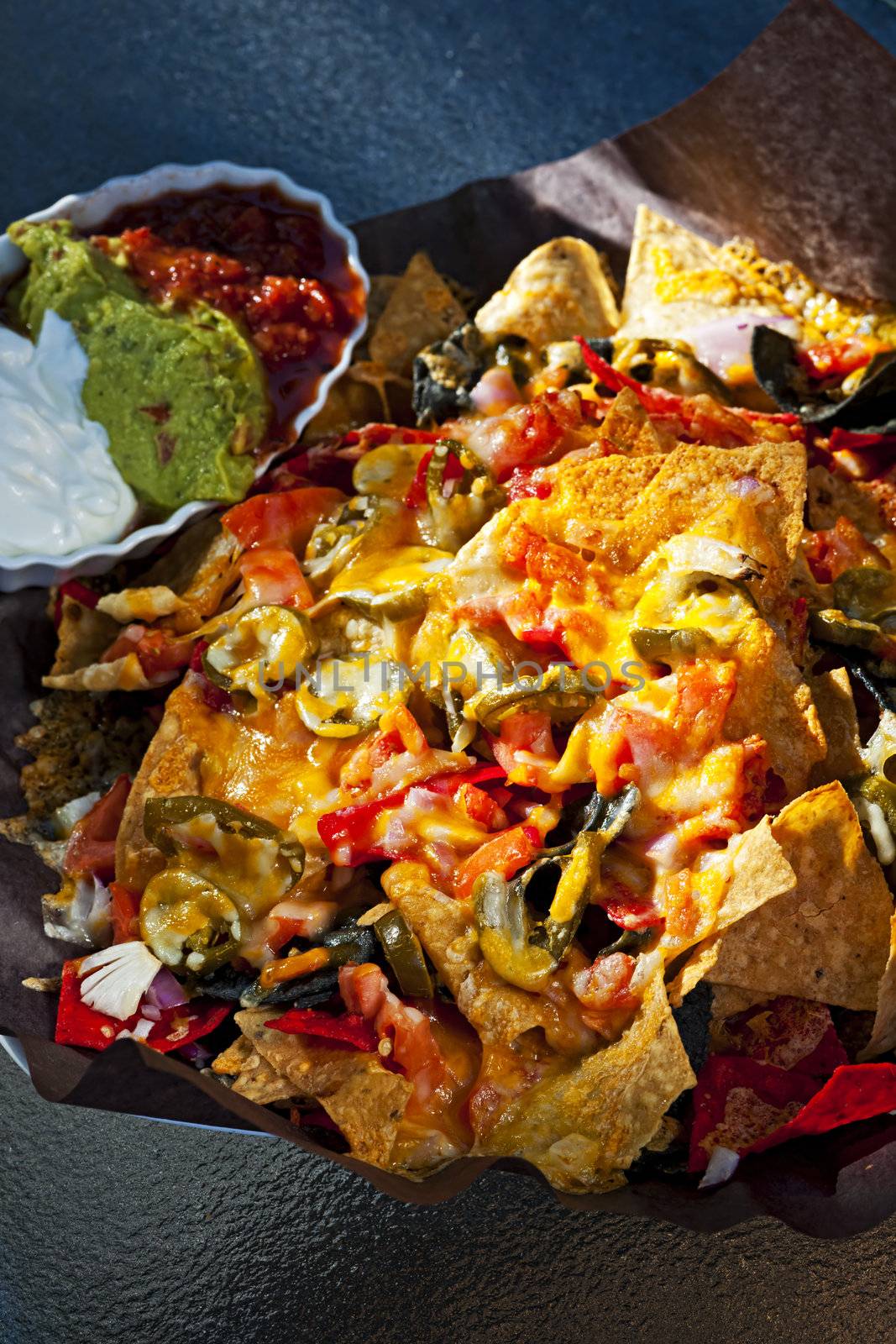 Basket of nachos with cheese jalapeno and toppings