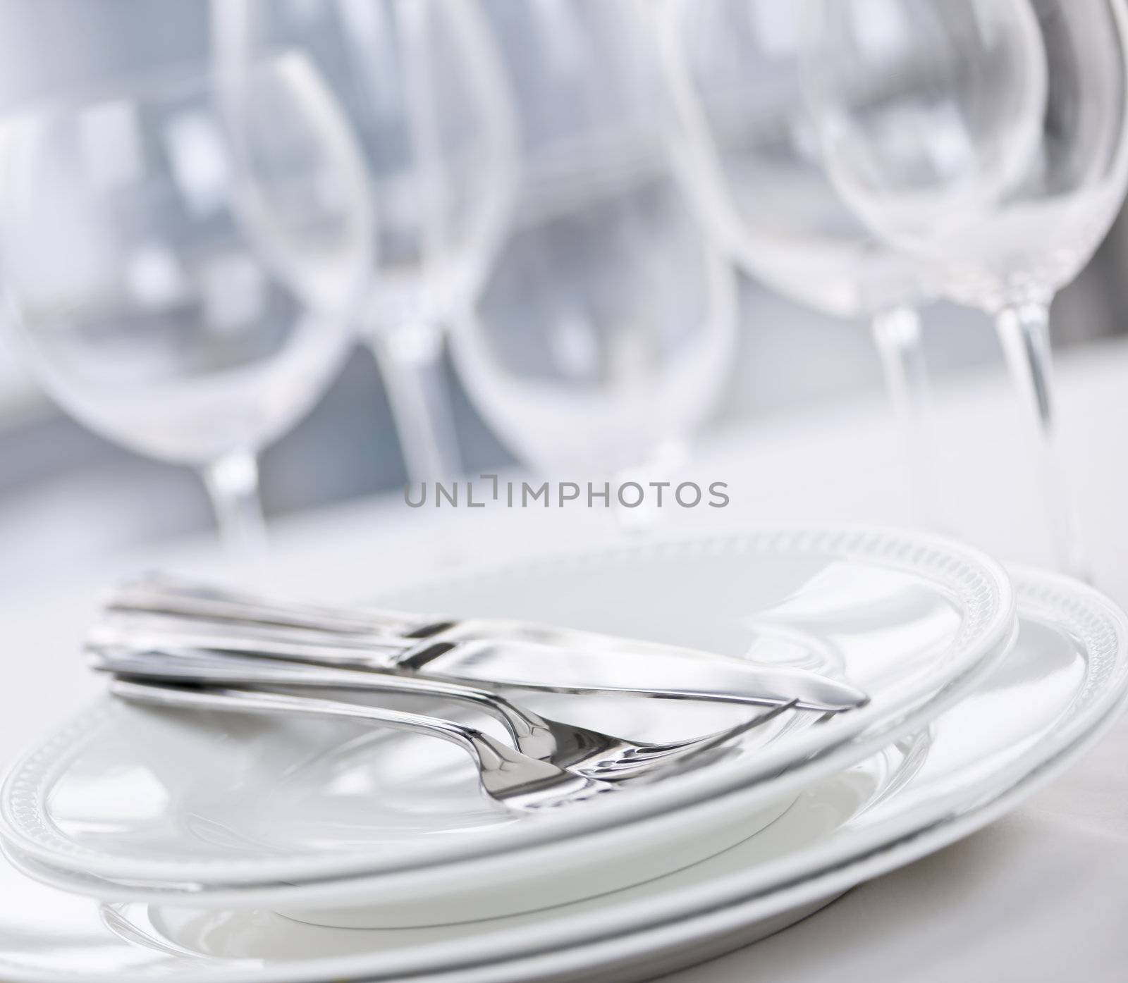 Elegant restaurant table setting with plates cutlery and stemware