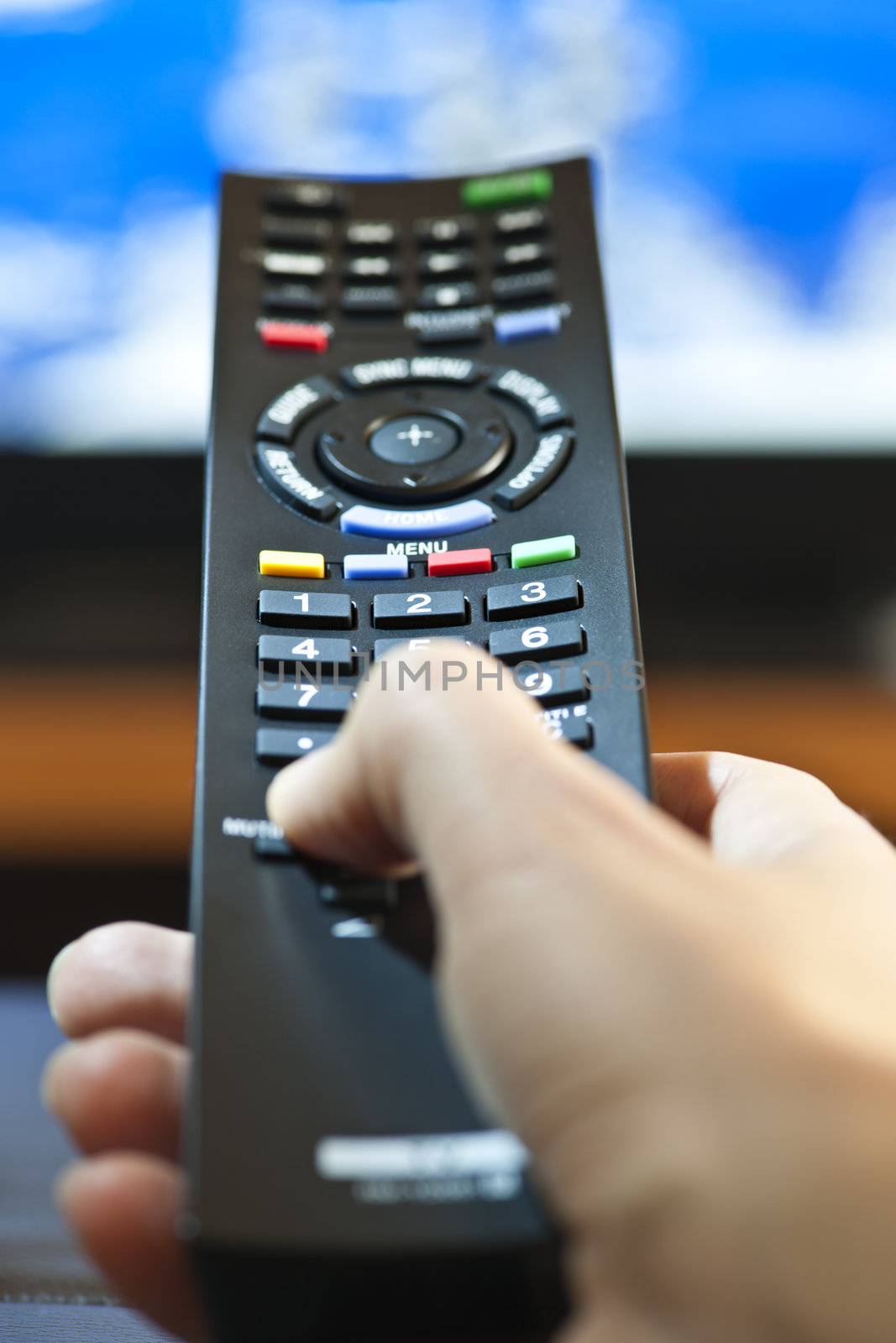 Hand with television remote control by elenathewise