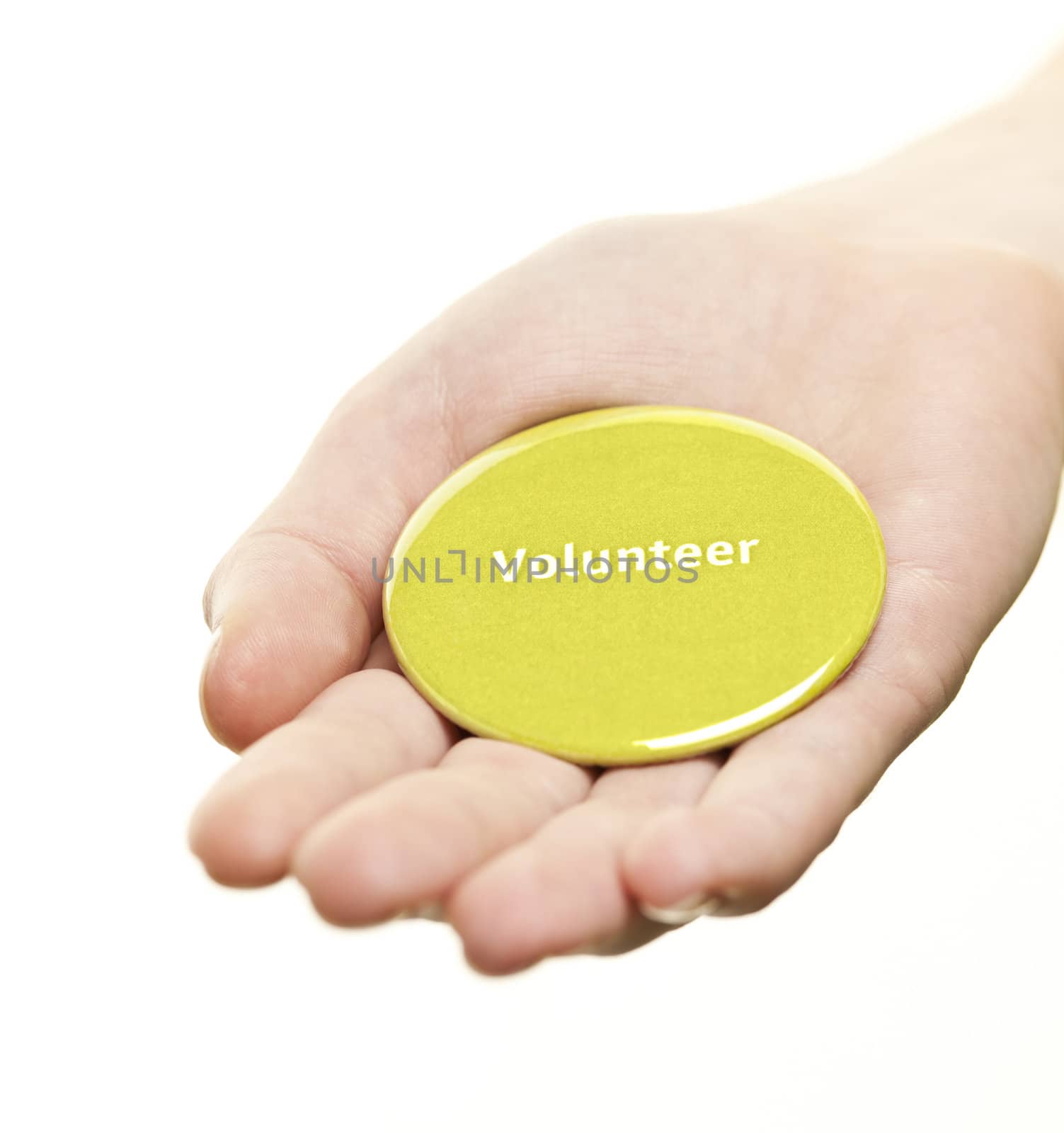 Hand holding green round volunteer button isolated on white