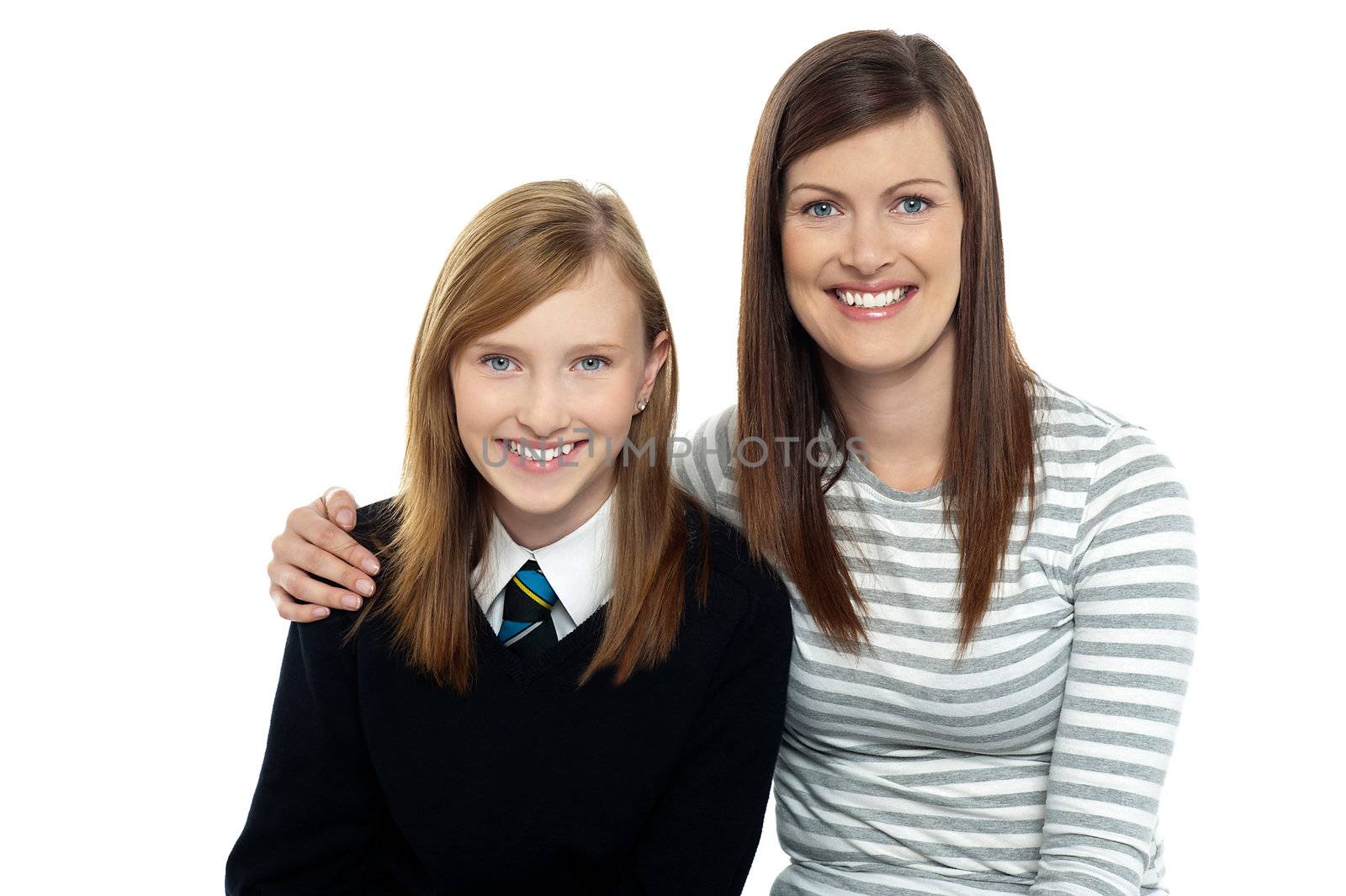 Snap shot of a mom with her arms around her cute daughter dressed in school uniform.