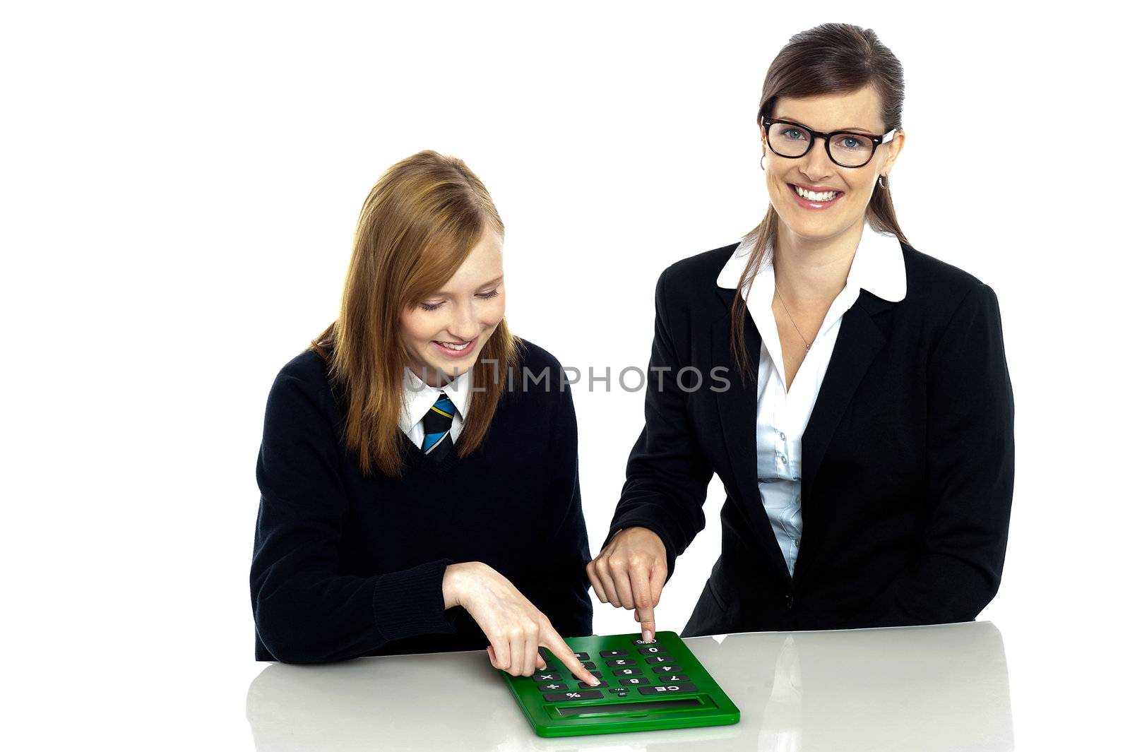 Pretty teacher and student working on a large green calculator together.