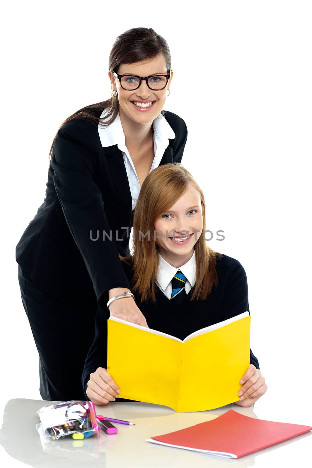 Teacher instructing student and helping her by stockyimages