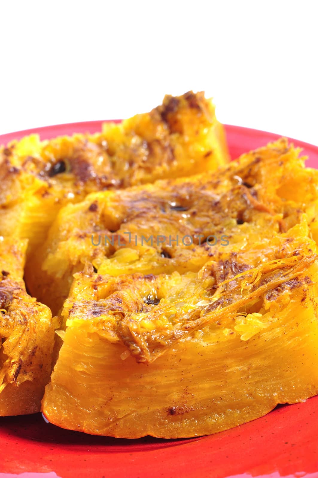 Closeup of steamed pumpkin with cinnamon and raisin on white background