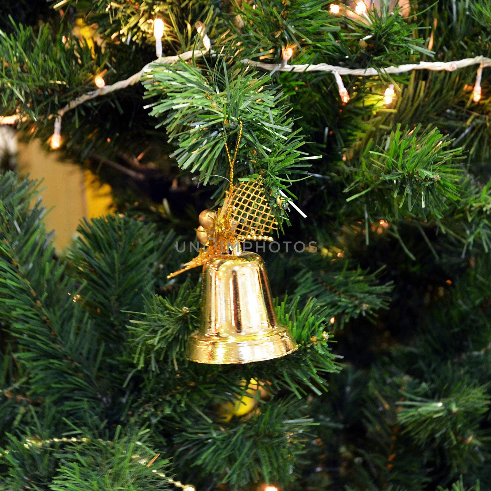 Christmas tree with golden bell  hanging on a green spruce branch. 