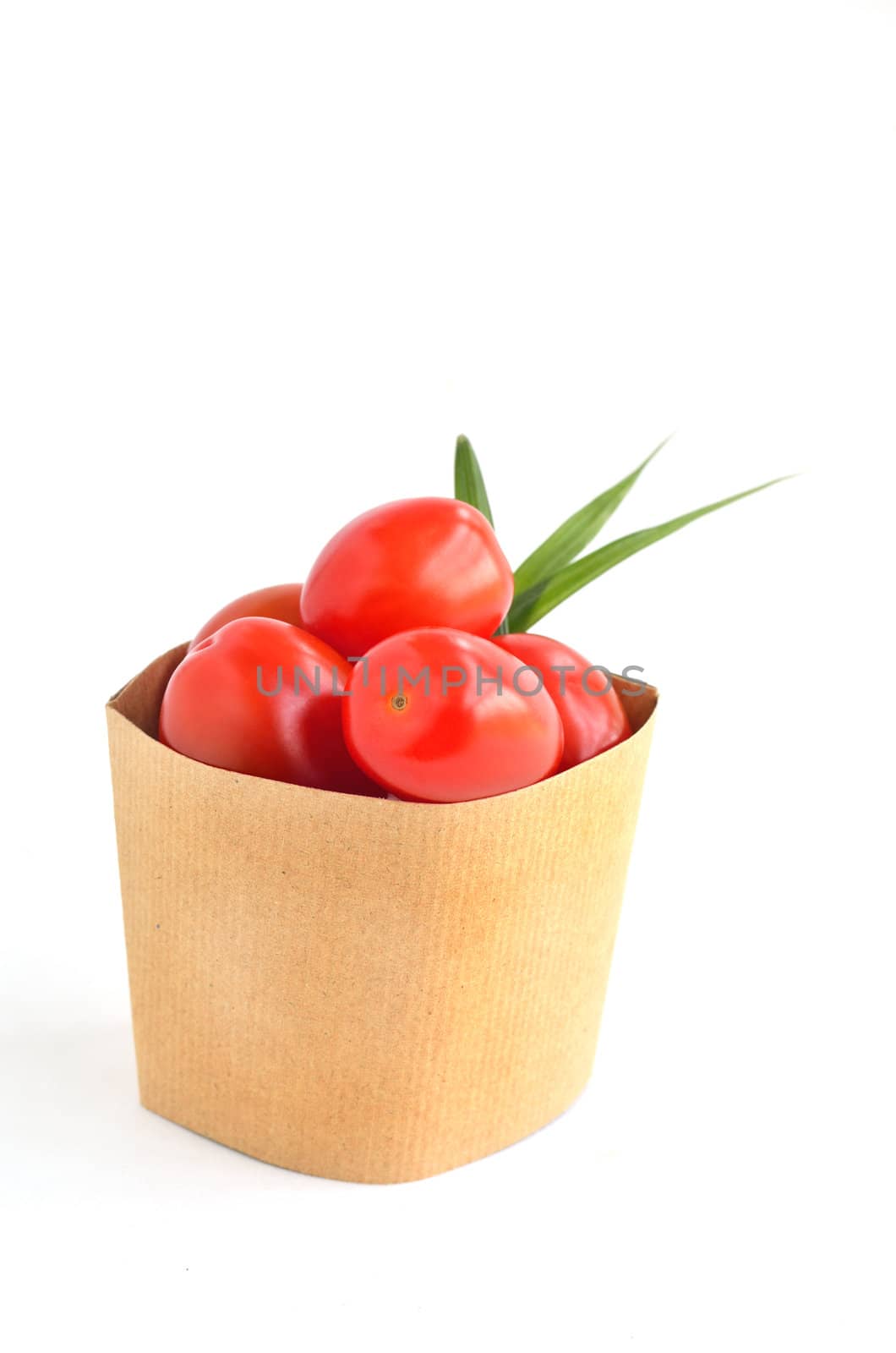Tomatos in paper bag isolated on white background