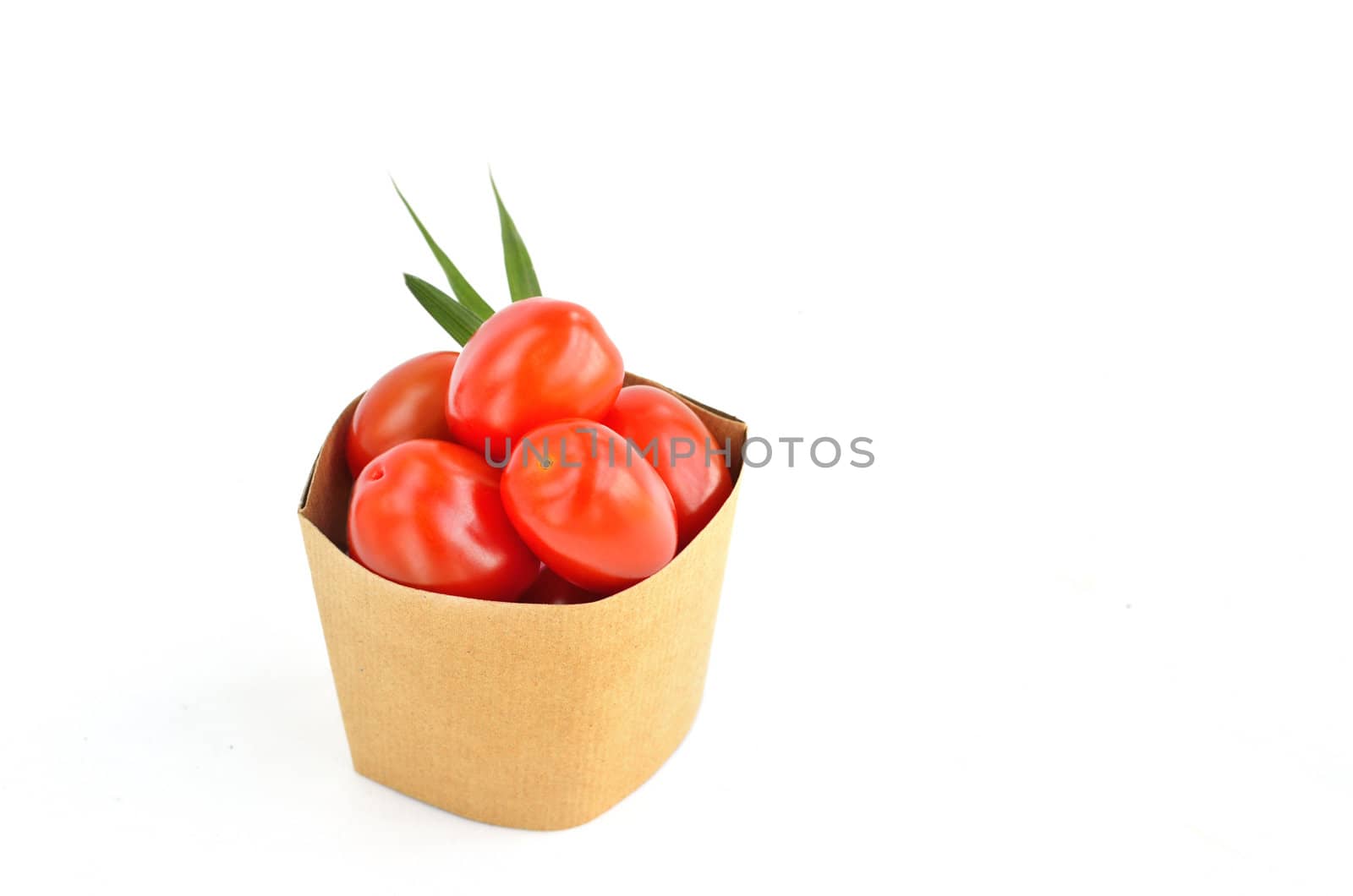 Tomatos in paper bag isolated on white background