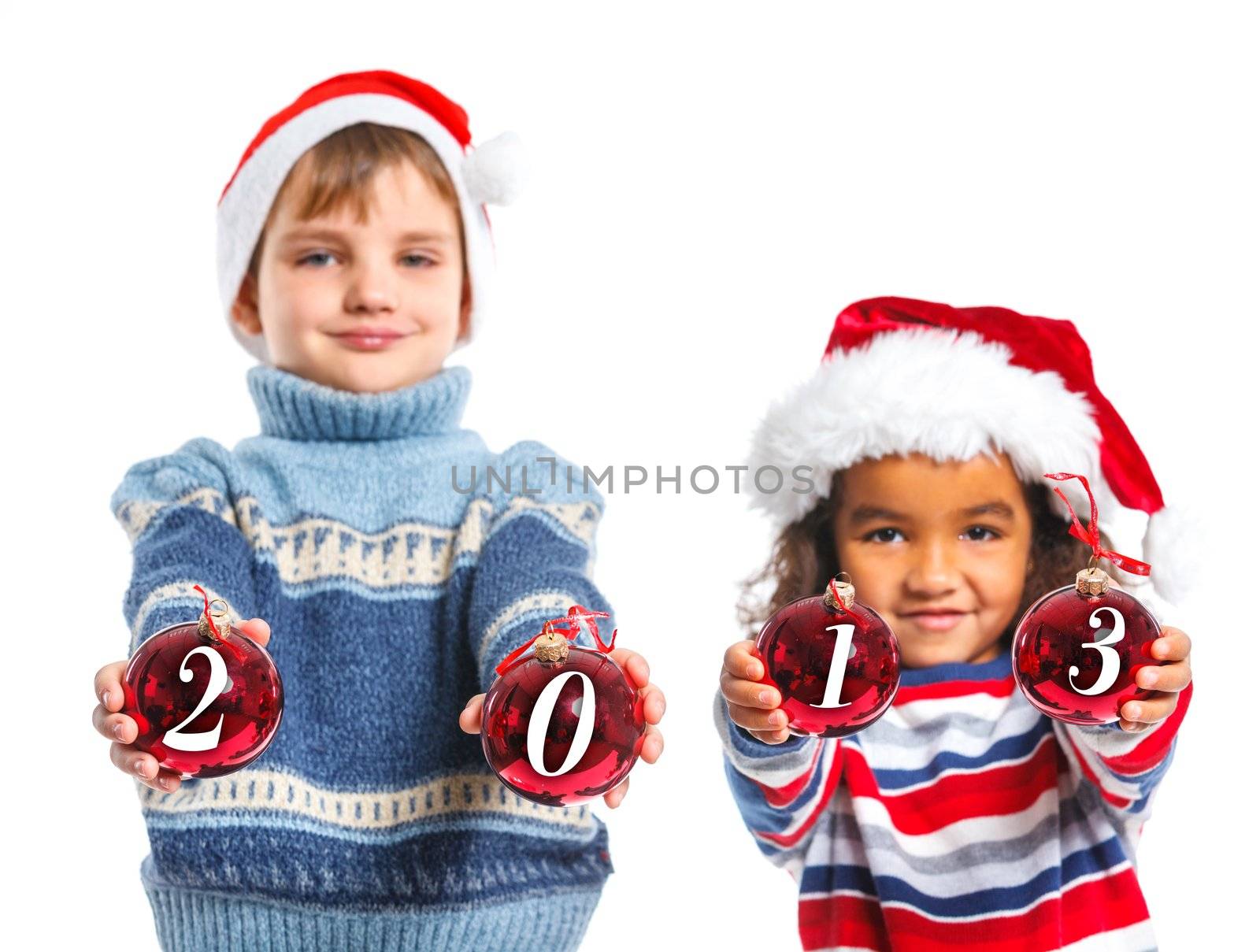 Kids in Santa's hat holding a christmas ball with 2013 against a white background. Focus on the ball