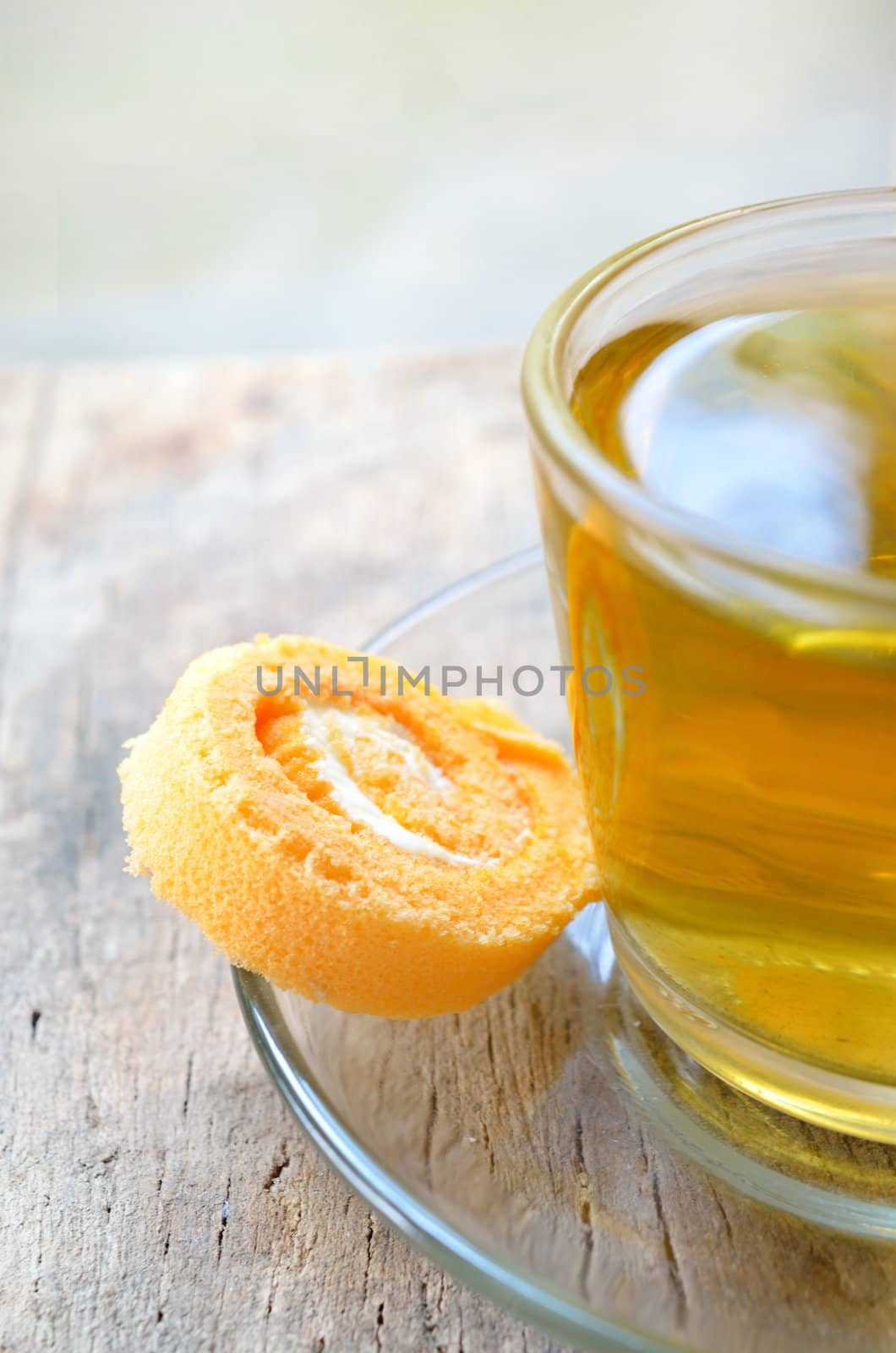 Roll cake and cup of tea on wood background