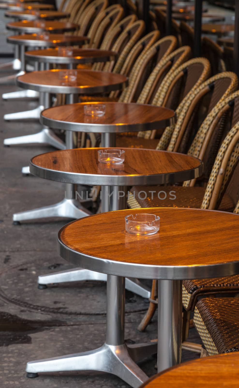 Row of tables and chairs on a traditional street terrace in Paris.