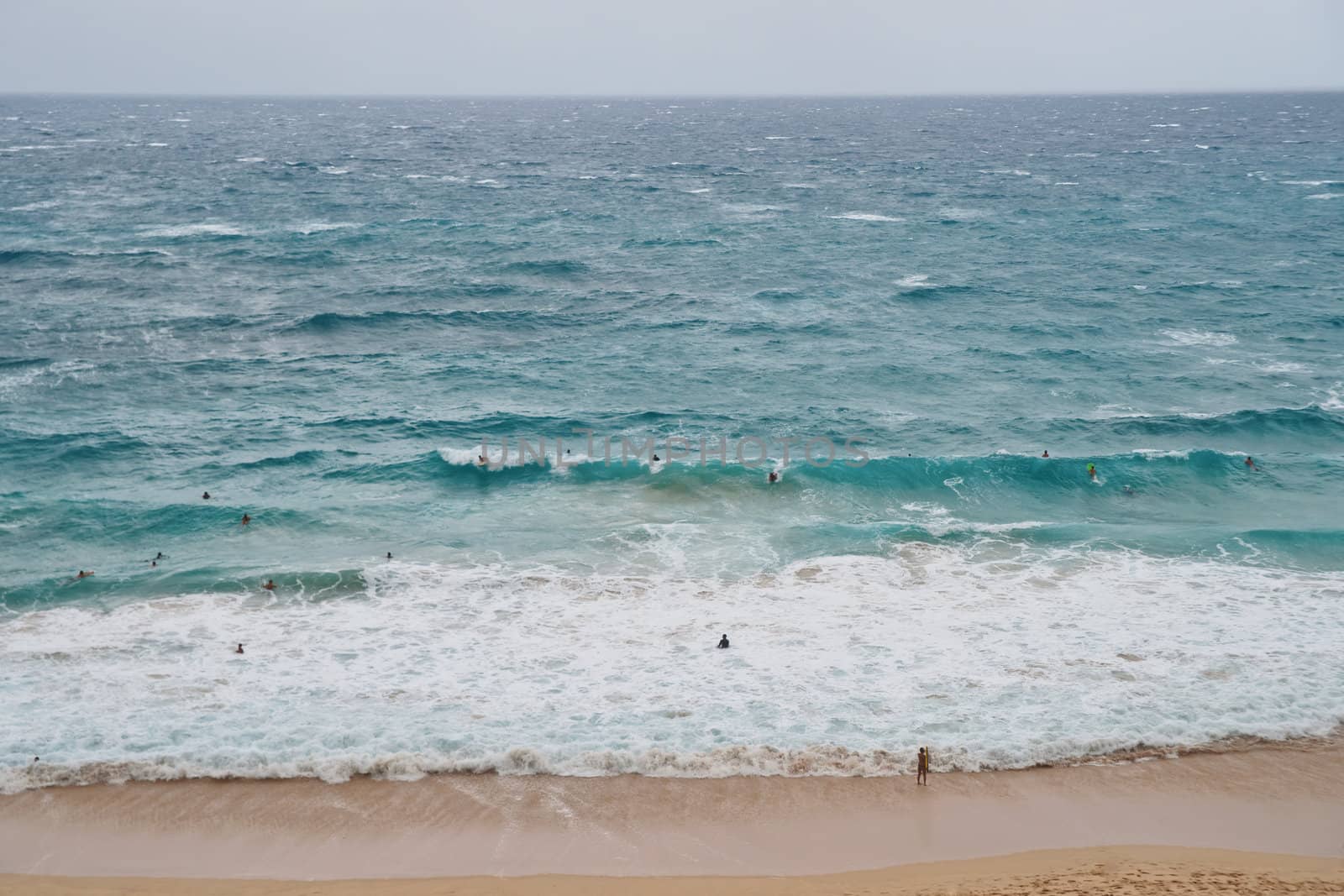 Crowded Beach in Oahu Island Hawaii. Surfers riding waves