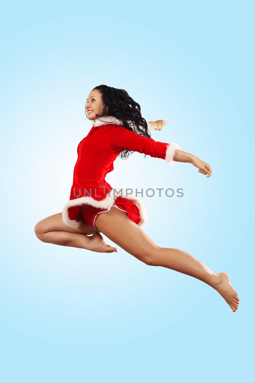 Happy smiling woman in red xmas costume jumping high