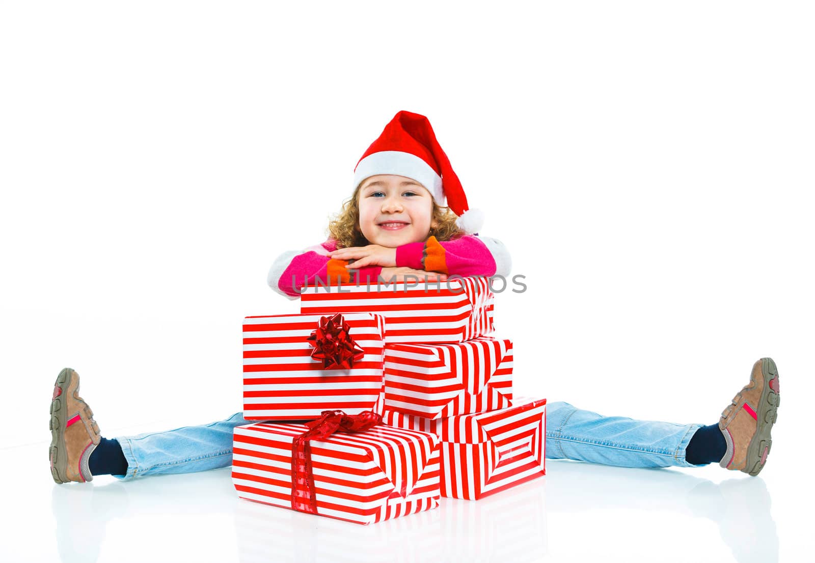 Smiling little girl in Santa's hat with gift box, isolated on white