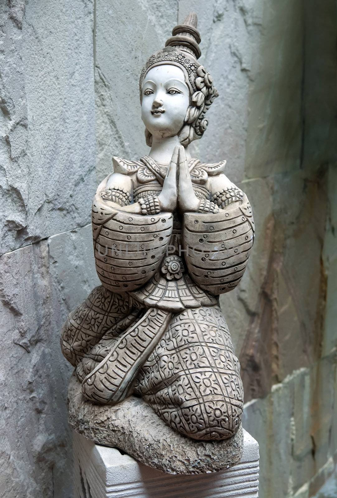 Asian statue in the form of a girl praying