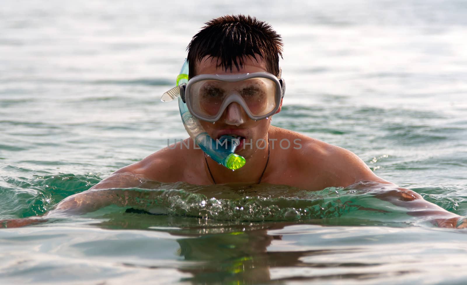 The man in the sea in a mask with a tube