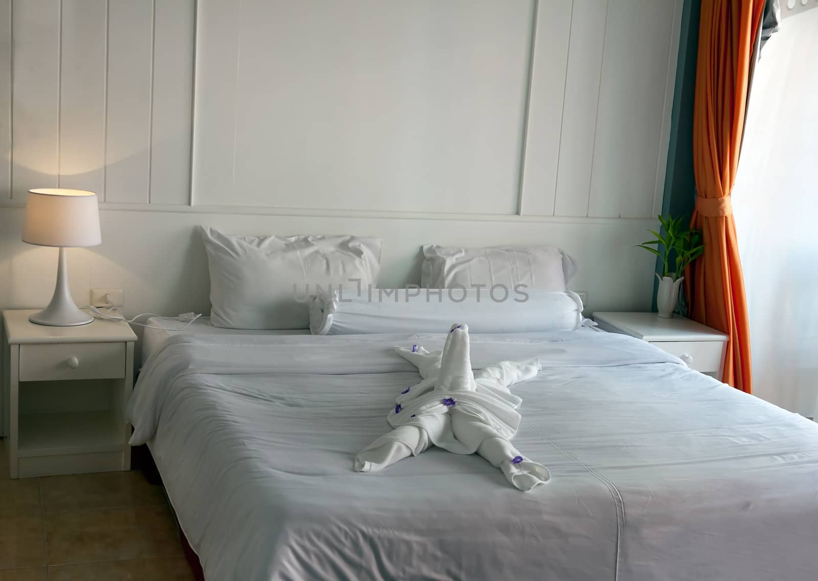 bed in a hotel with towels laid figured
