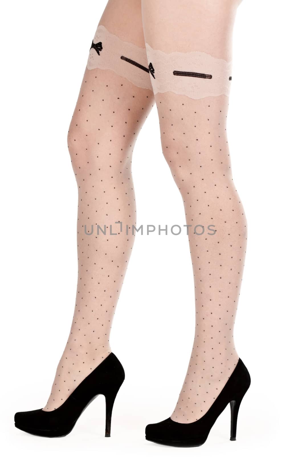 shapely female legs in pantyhose and shoes with heels in the studio on a white background