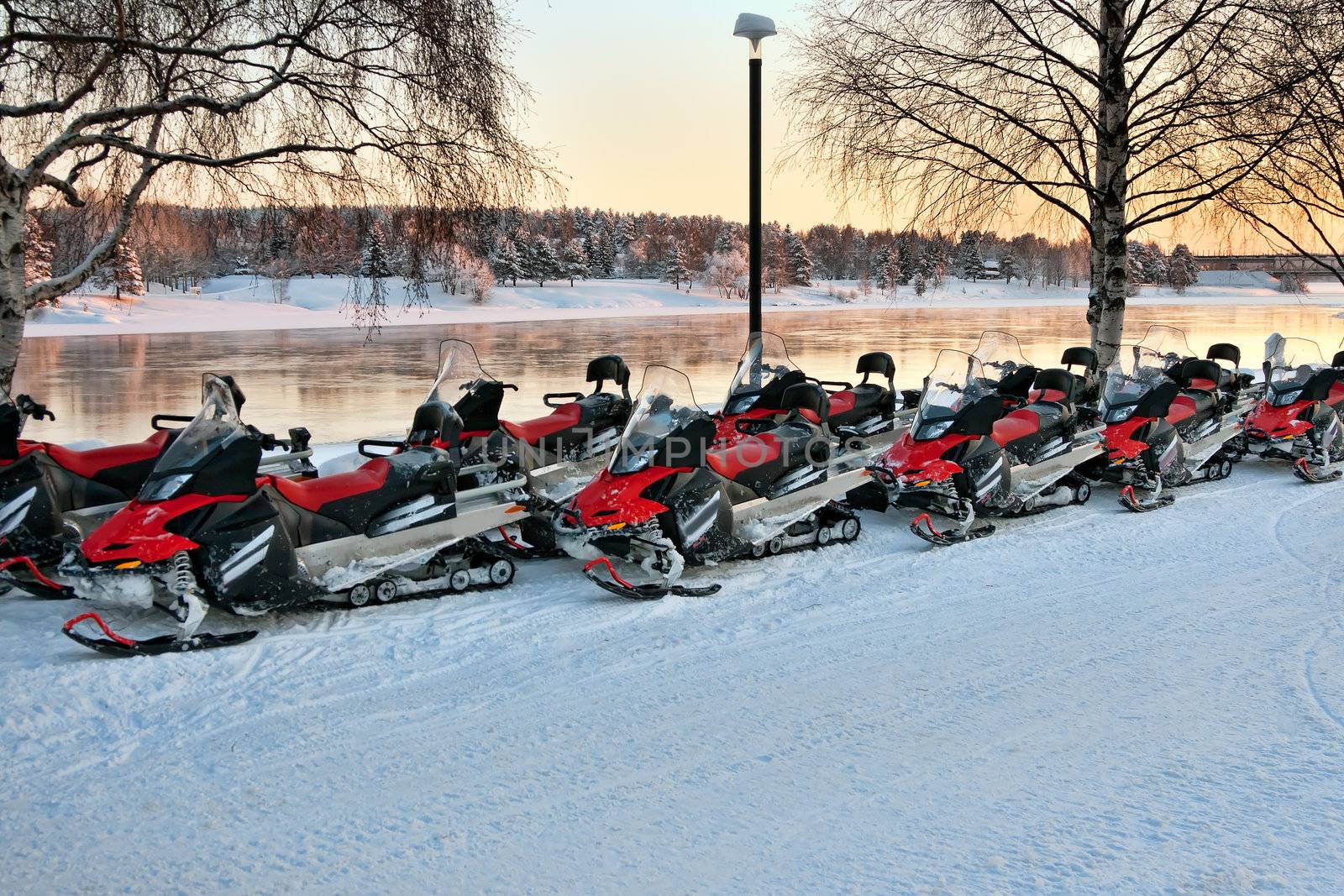 Vehicles are a number of snowmobiles in the parking lot
