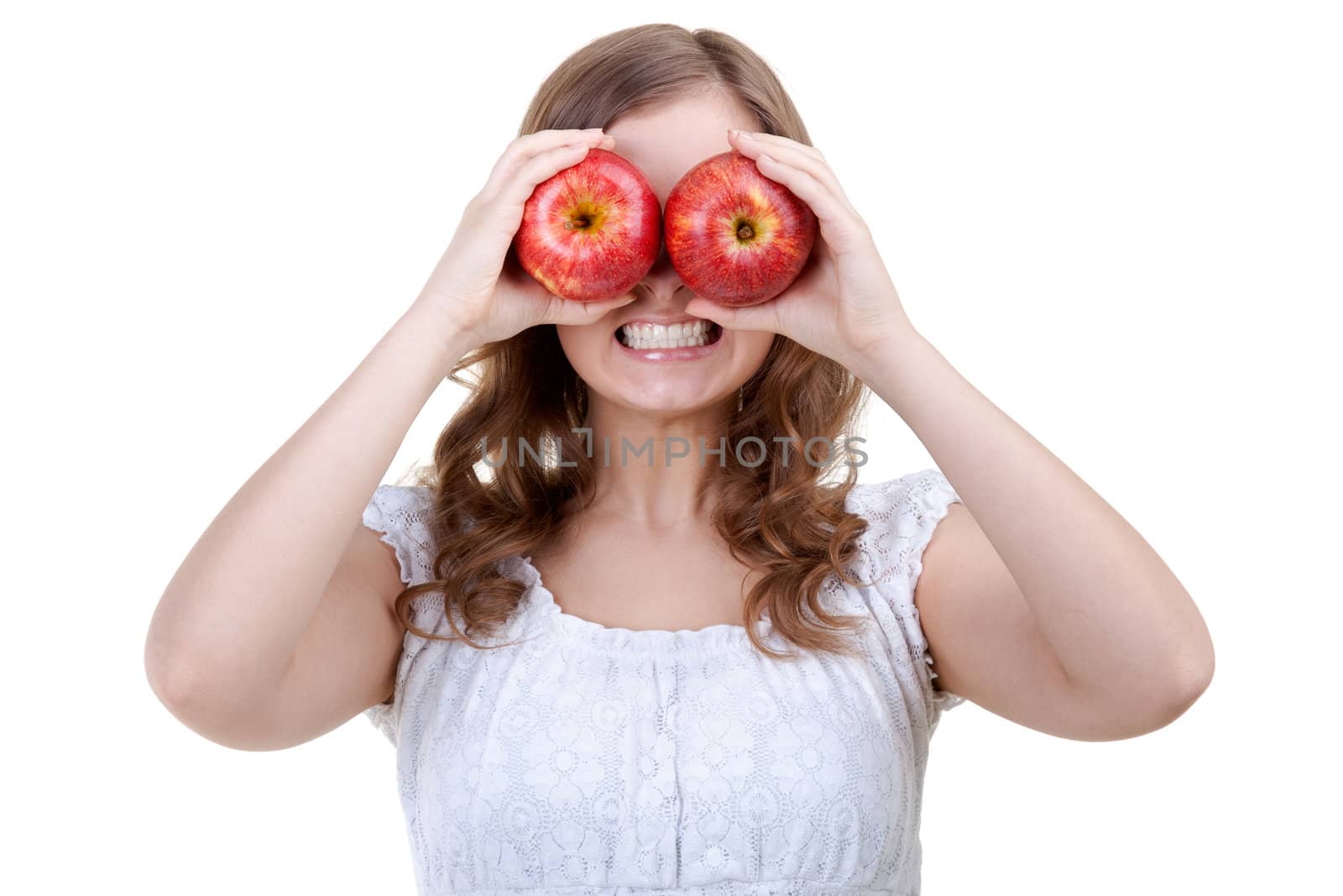 Young girl holding apple in front of the teeth shows