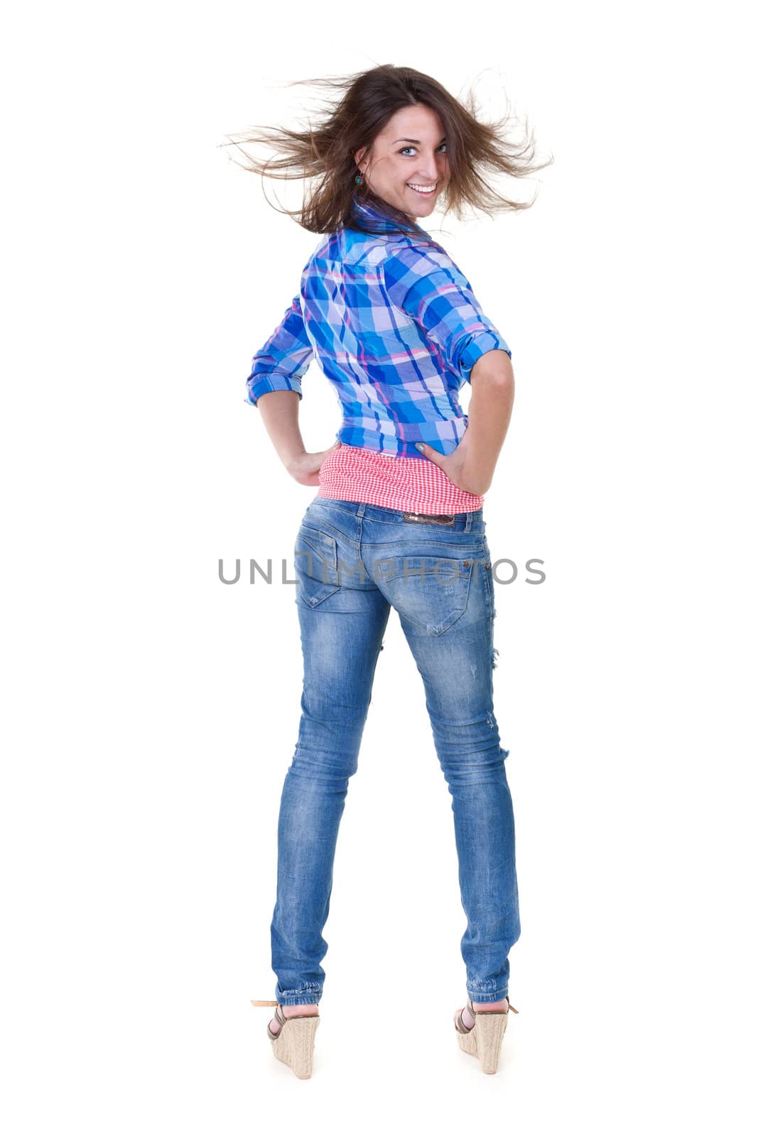 Beautiful girl in jeans turns out to back on a white background