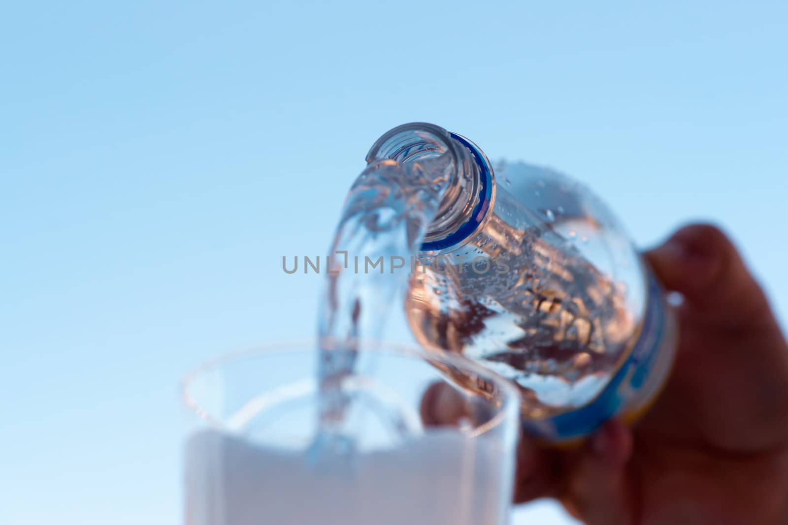 water is pouring down from plastic bottle, image on white background