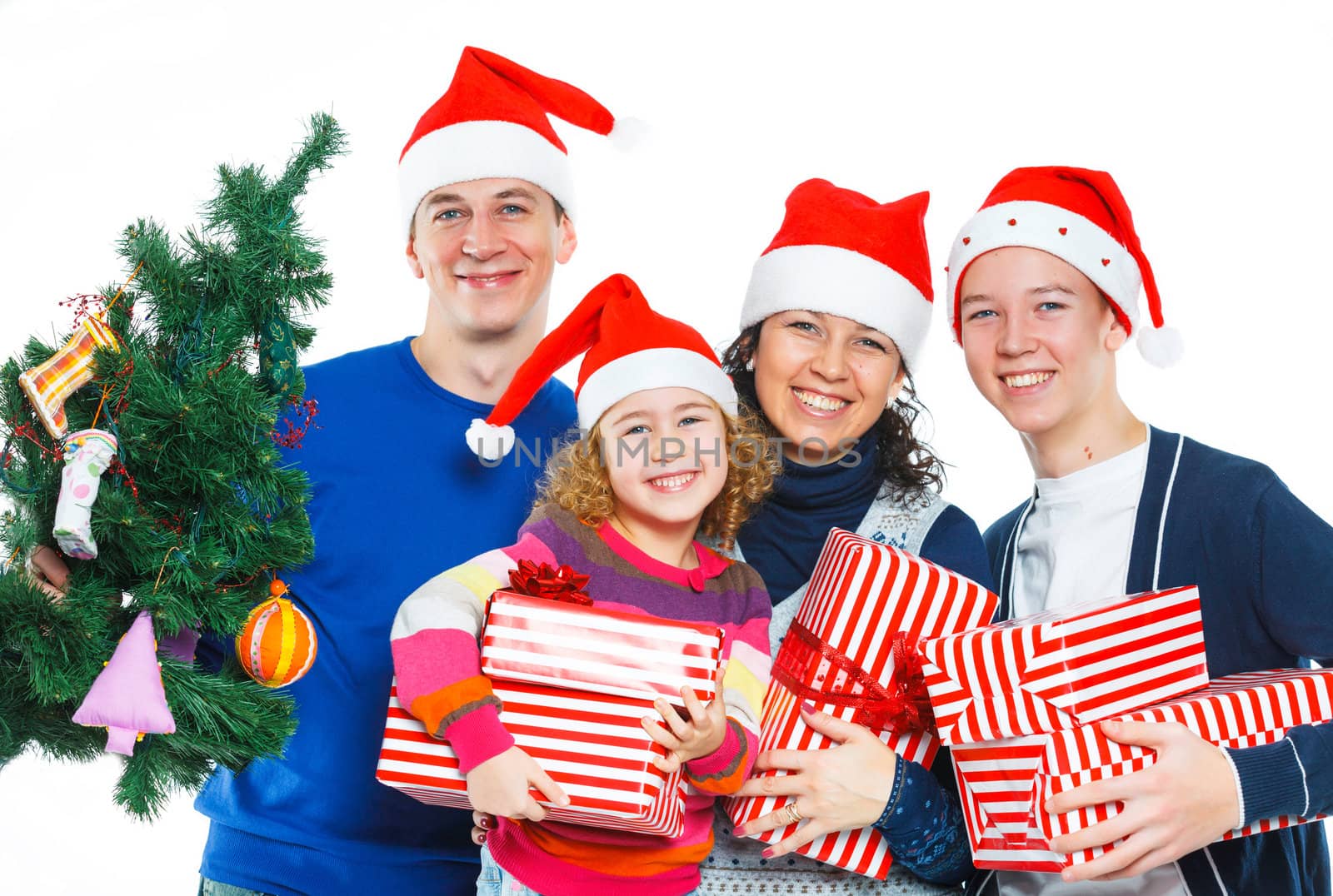 Portrait of friendly family in Santa's hat with gift box and christmas tree, isolated on white