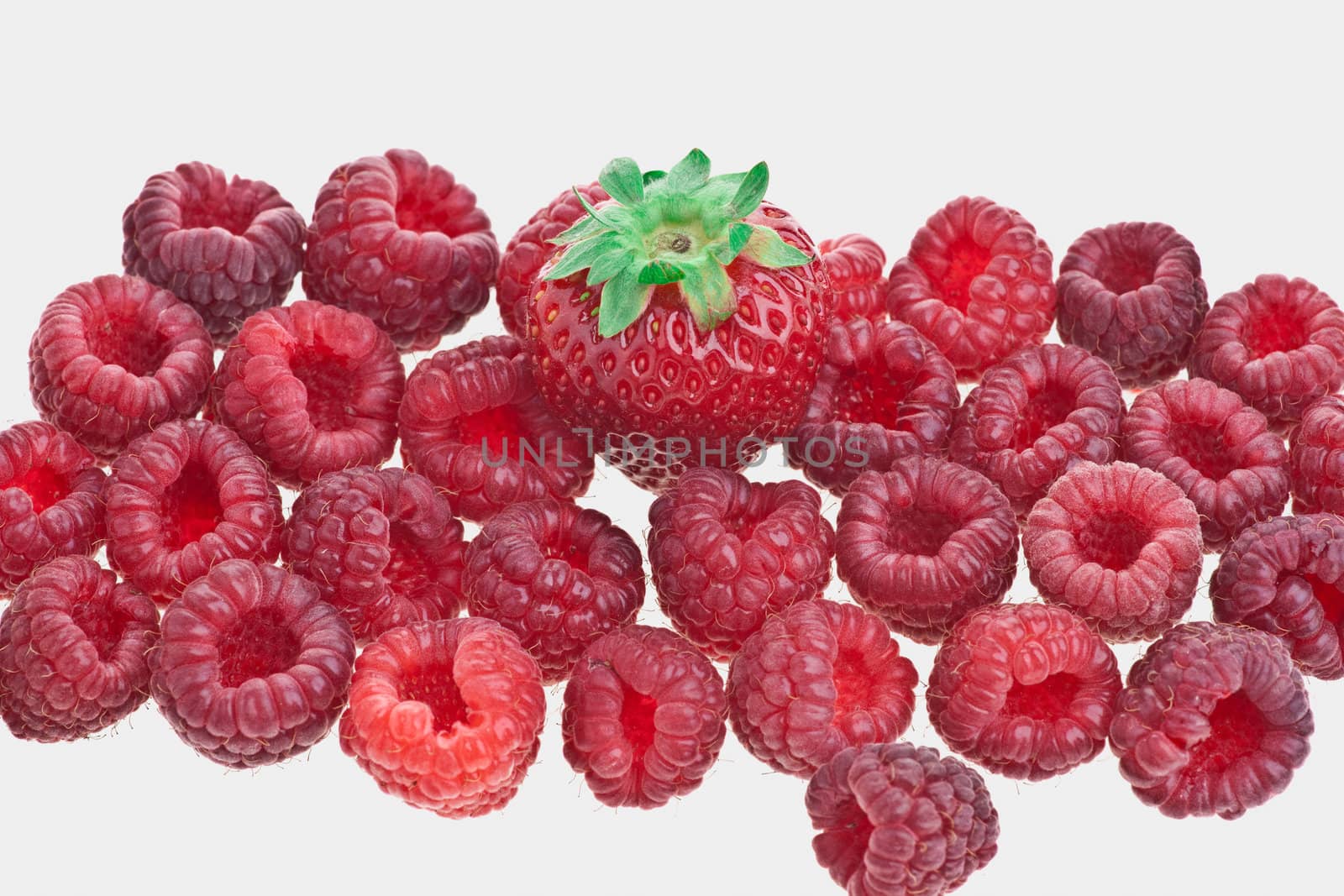 Macro of a strawberry and raspberries against white background 