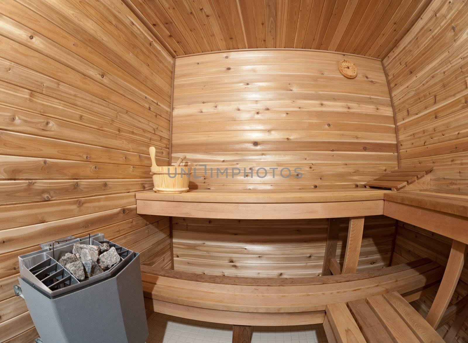 a sauna within a wood cabin with a bucket and towel inside the room