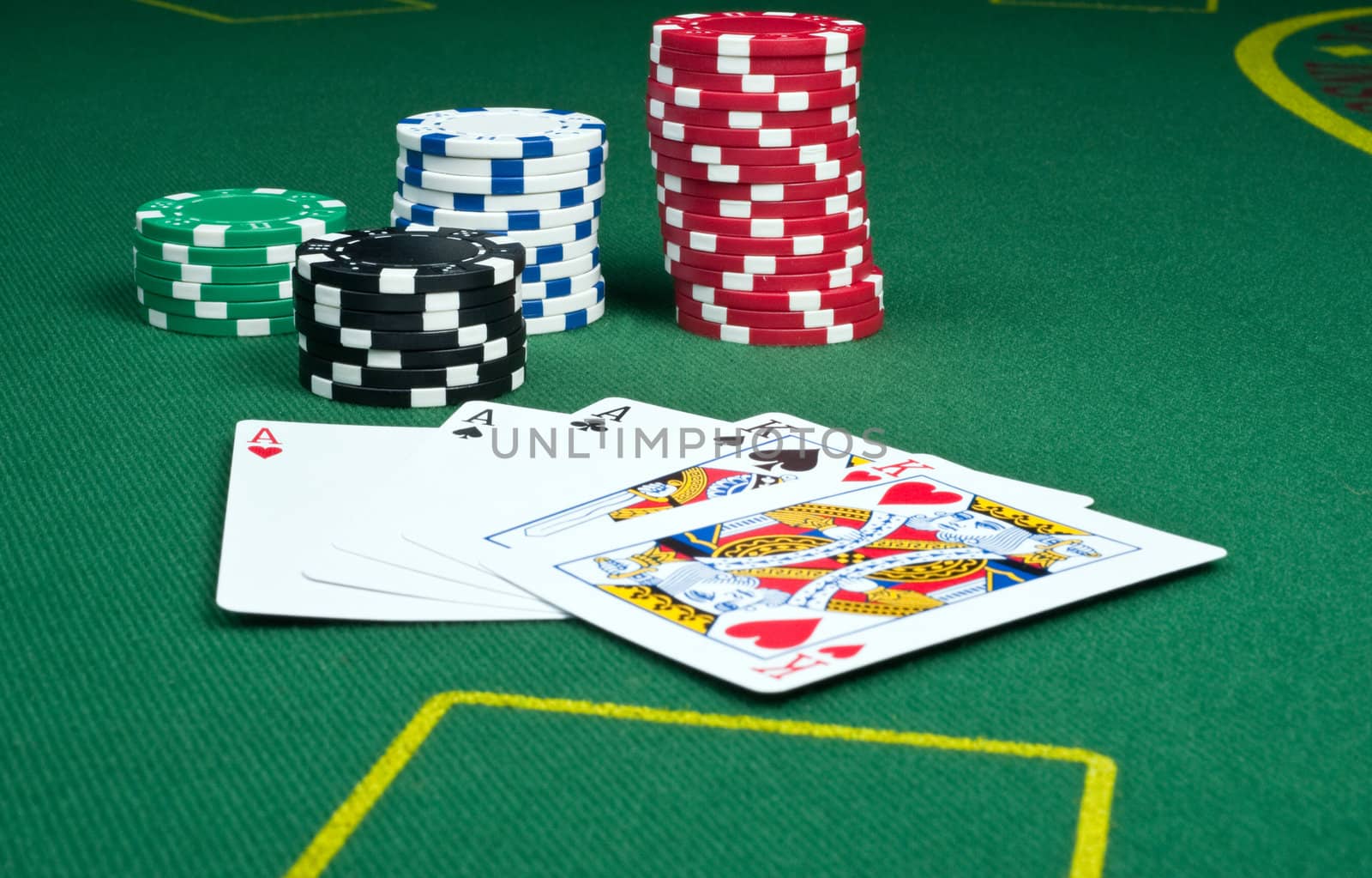Full house of aces over kings with stacks of poker chips