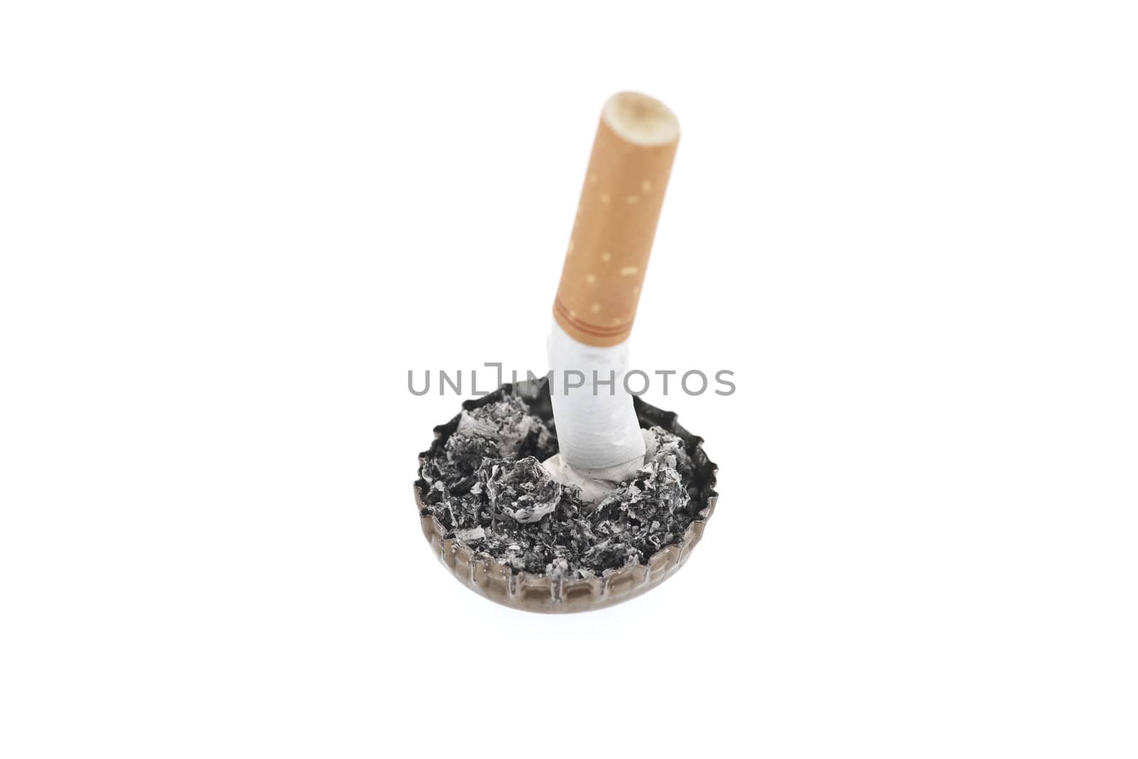 Quit smoking, cigarette butt in a bottle cap on white background